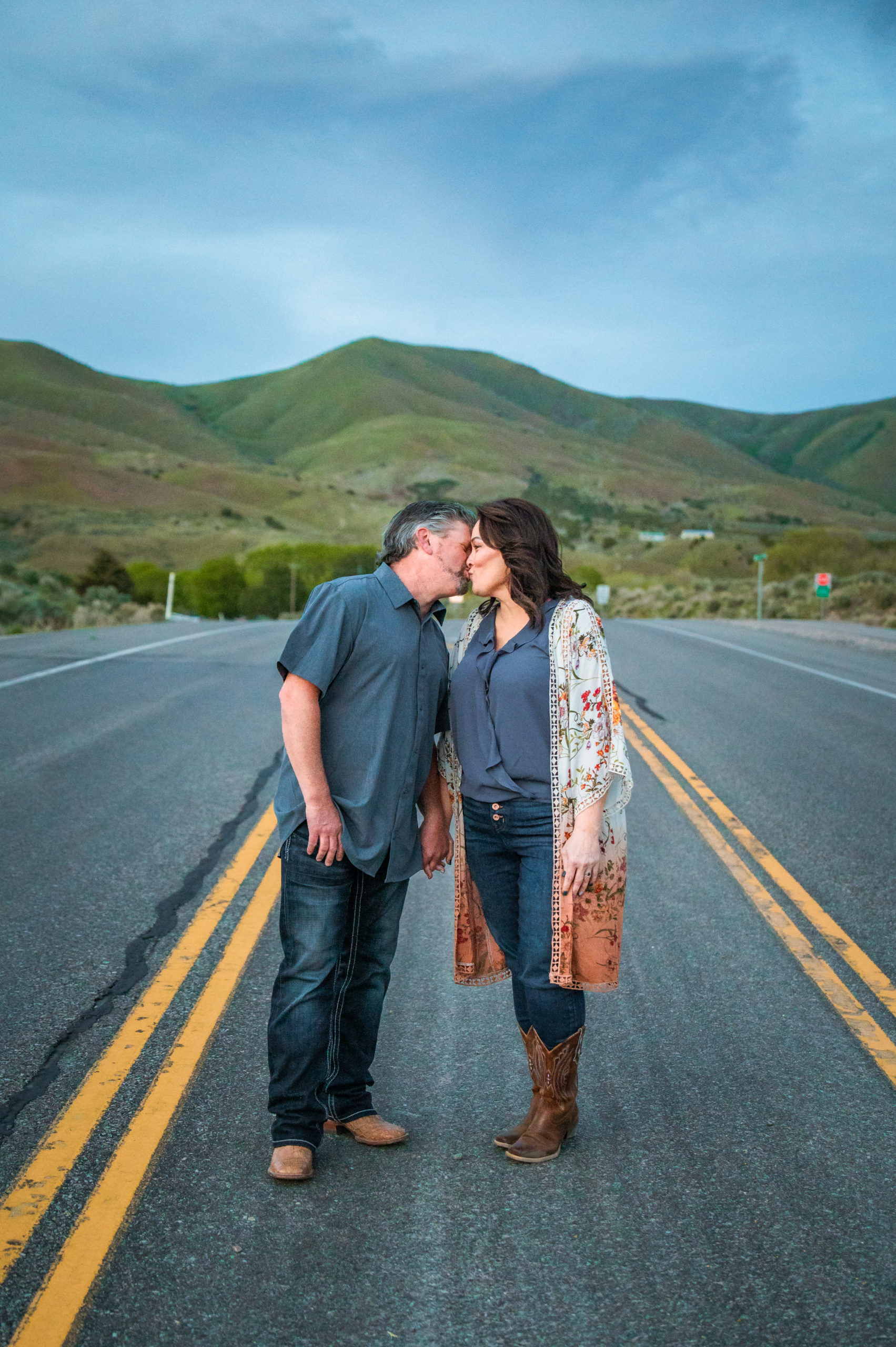 engaged couple kissing in street during outdoor portraits