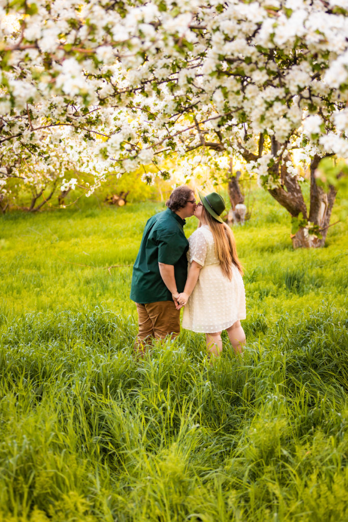 couple with backs to camera kissing during outdoor engagement shoot
