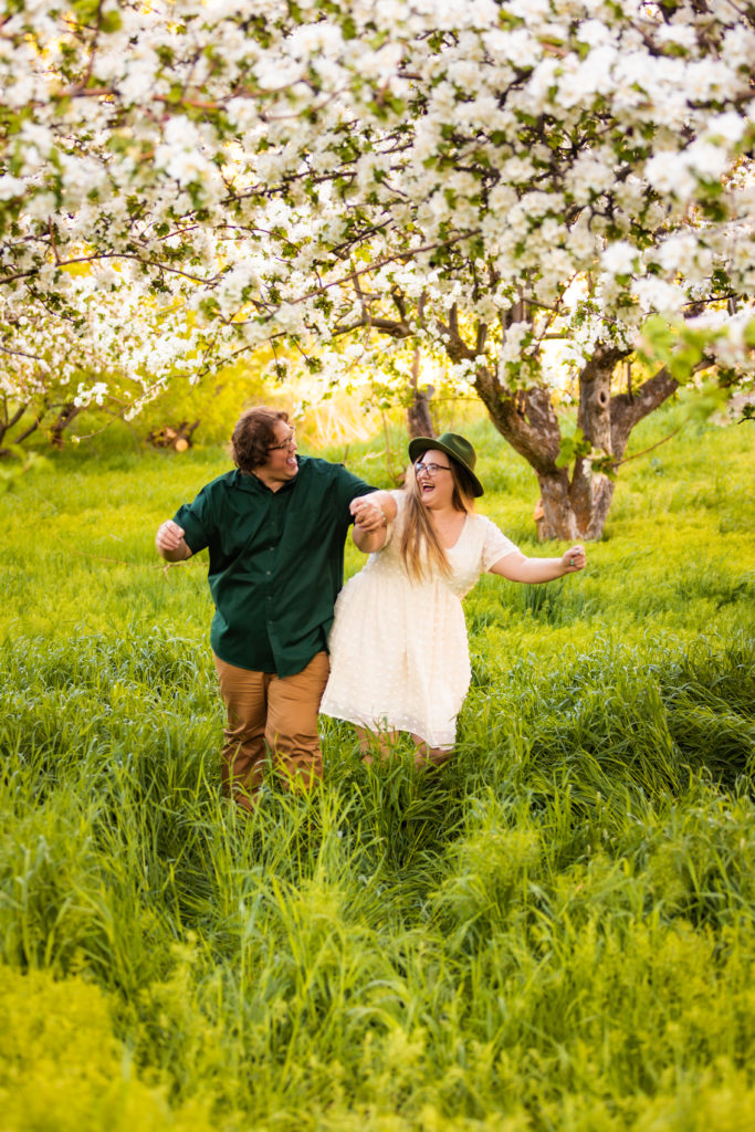 couple dancing and having fun in Idaho apple blossoms