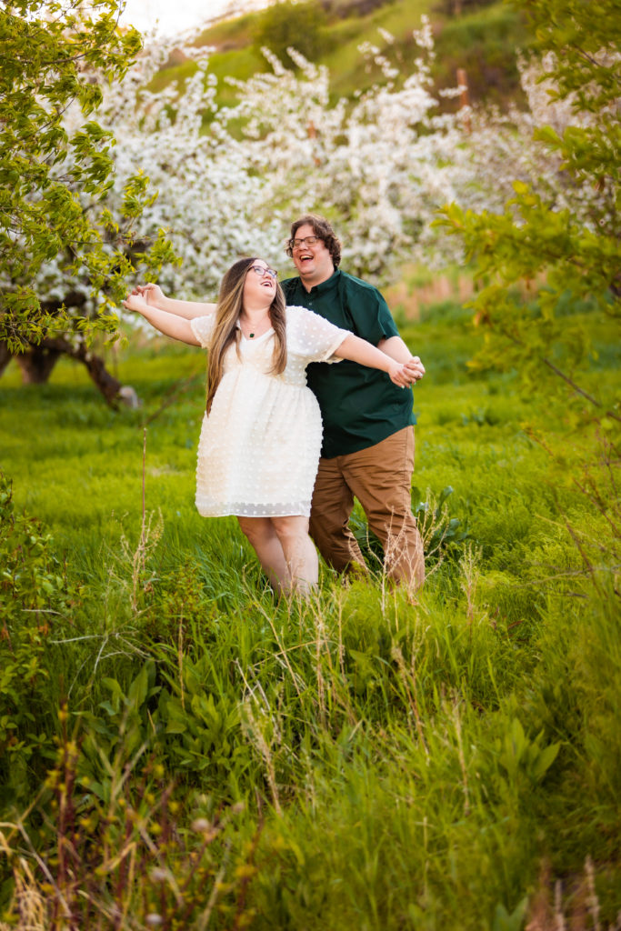 engaged couple laughing doing windmill pose during lively pocatello engagements