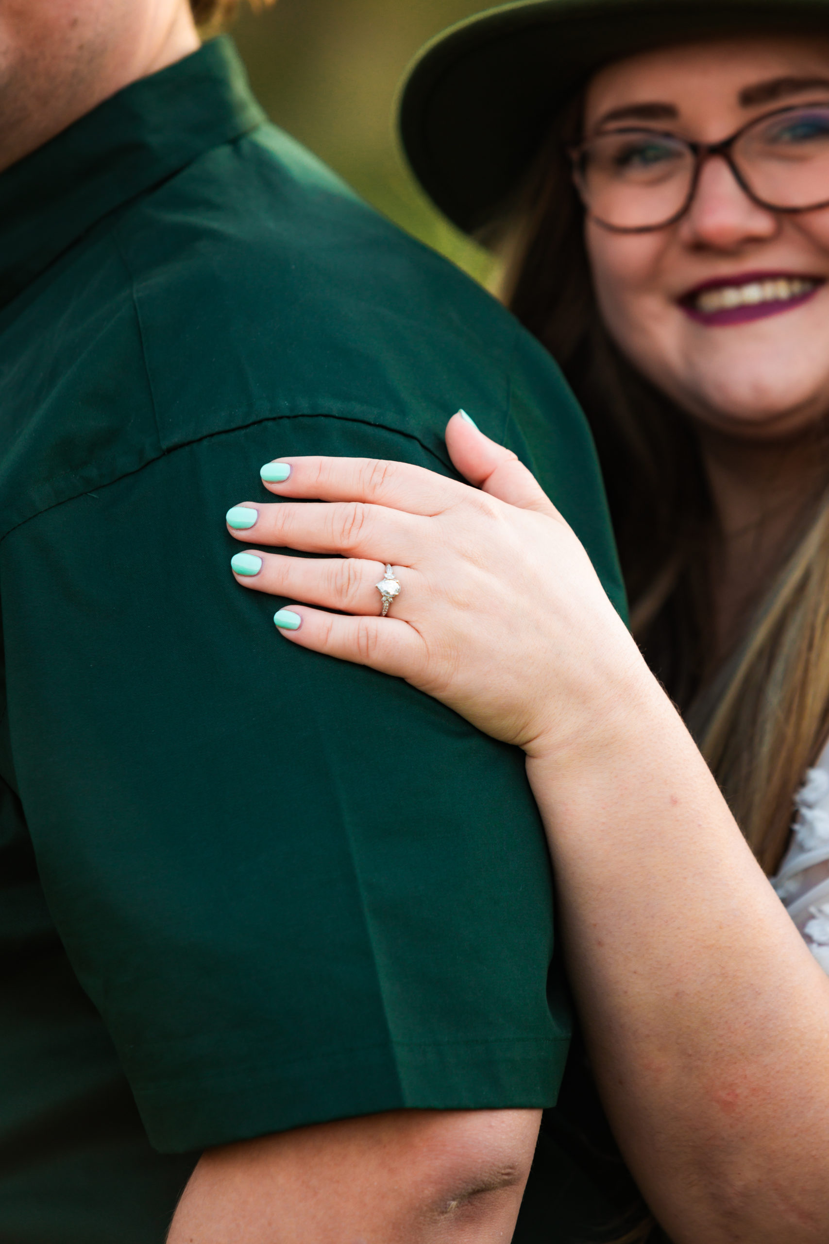 woman placing hand with engagement ring on fiance's shoulder 