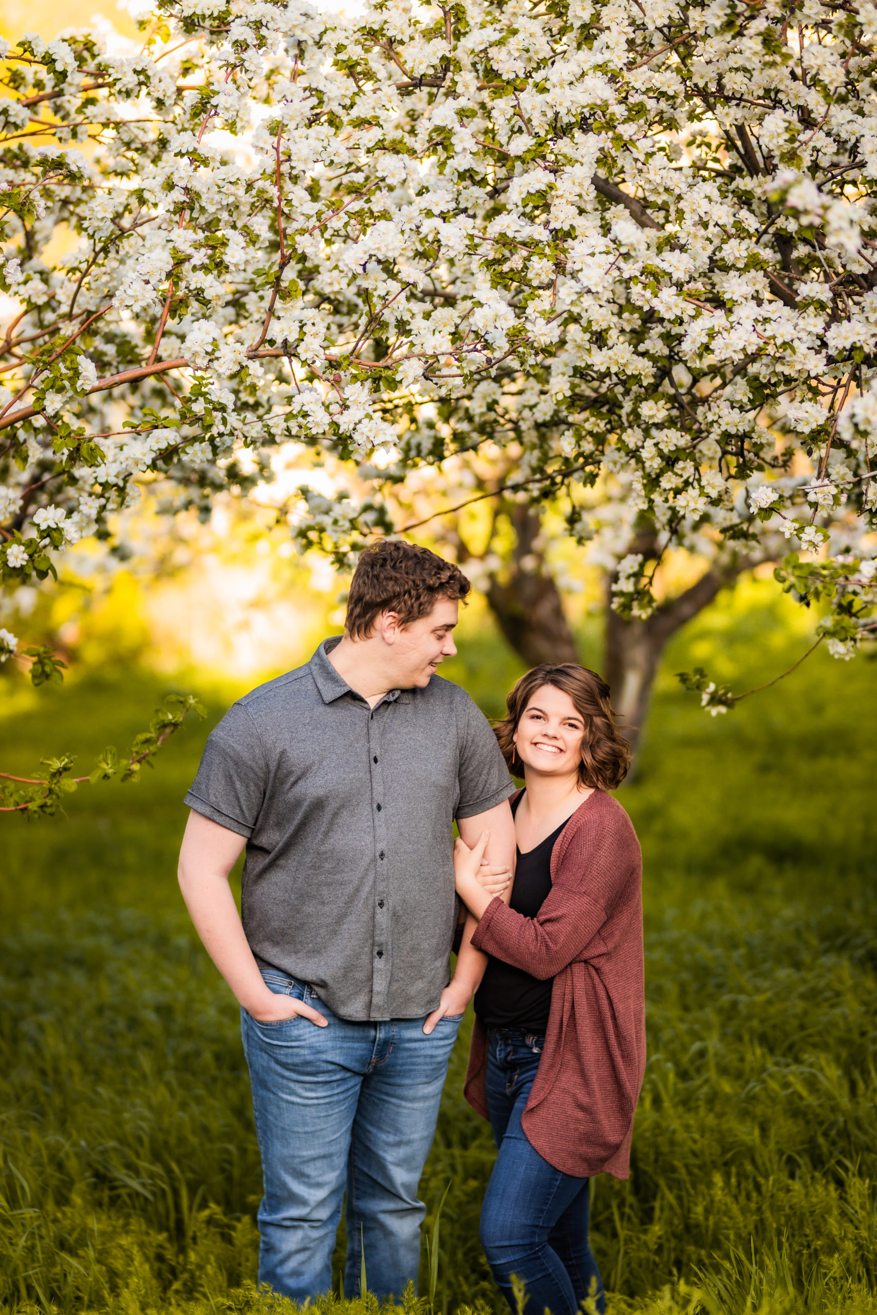 newly engaged couple holding hands during Pocatello Apple Blossom Engagements