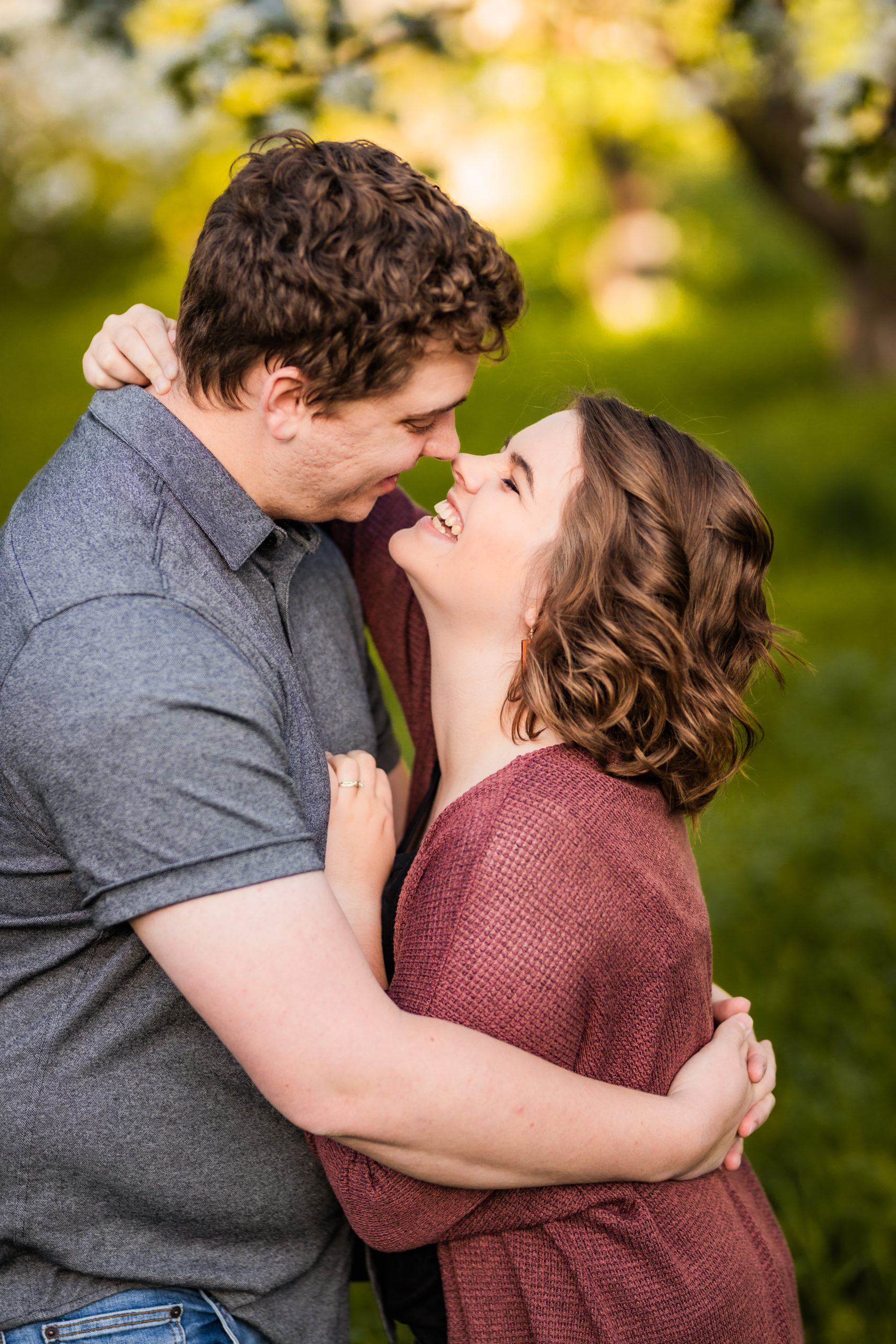 man and woman with noses together embracing during outdoor engagement session