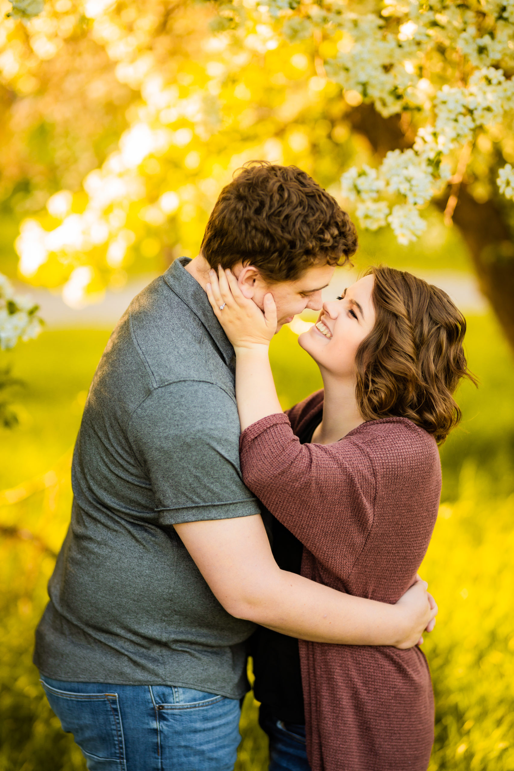 woman looking at man during apple blossoms engagement session