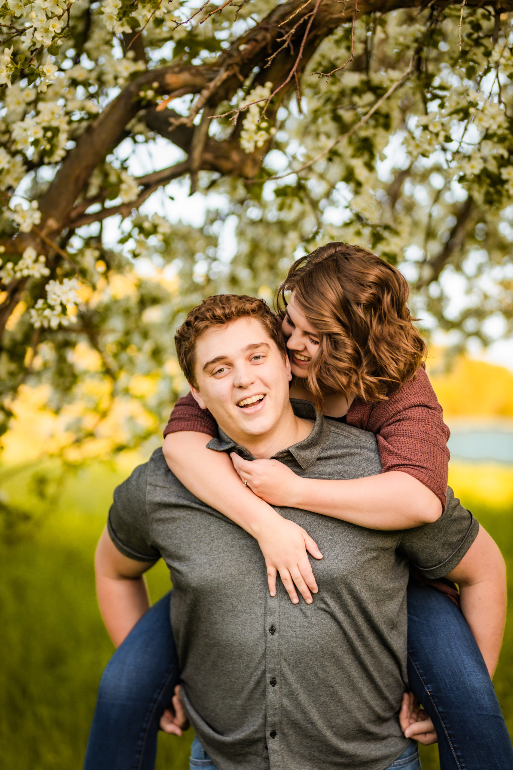 woman whispering in man's ear during engagement session