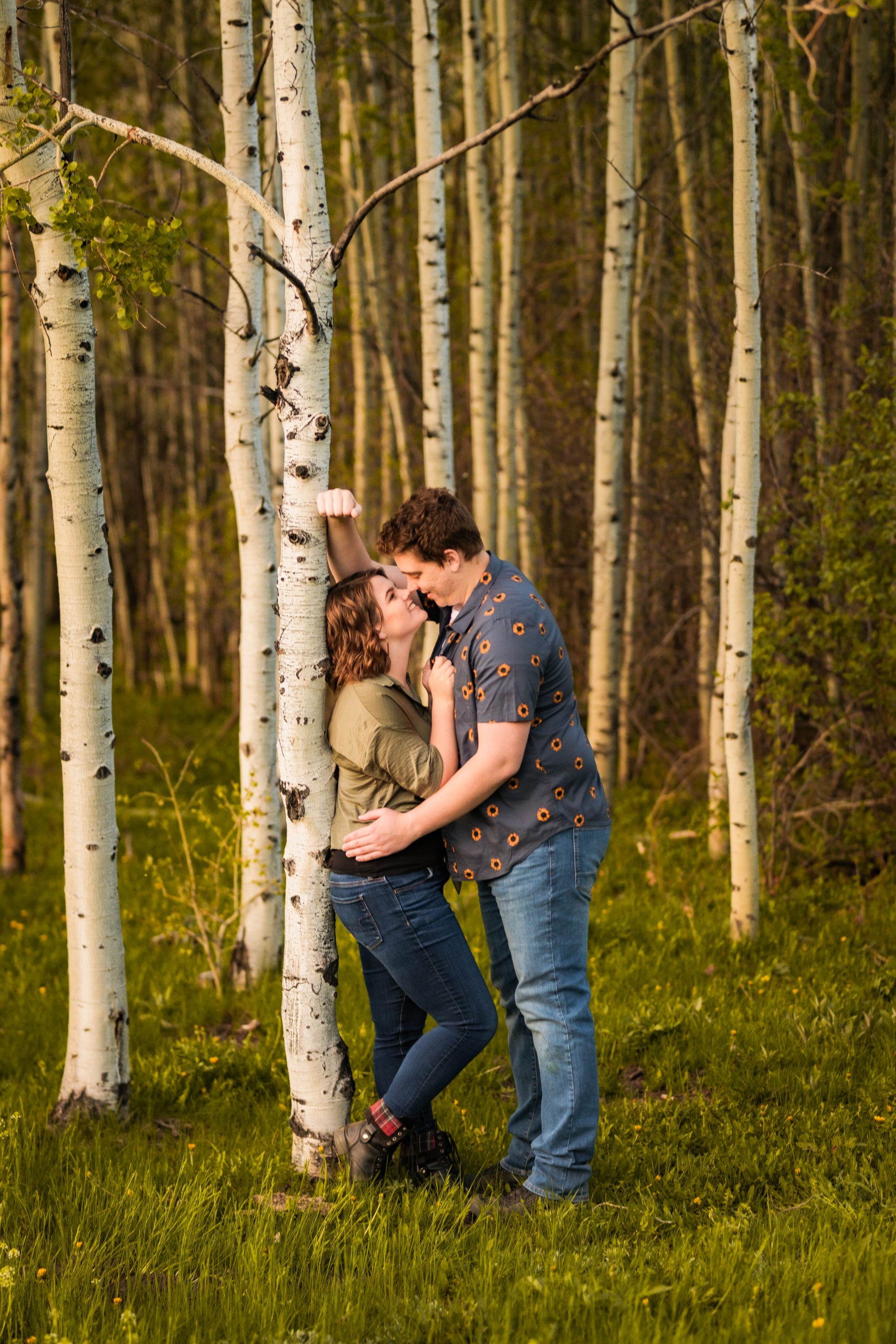woman leaning against tree kissing during outdoor portraits