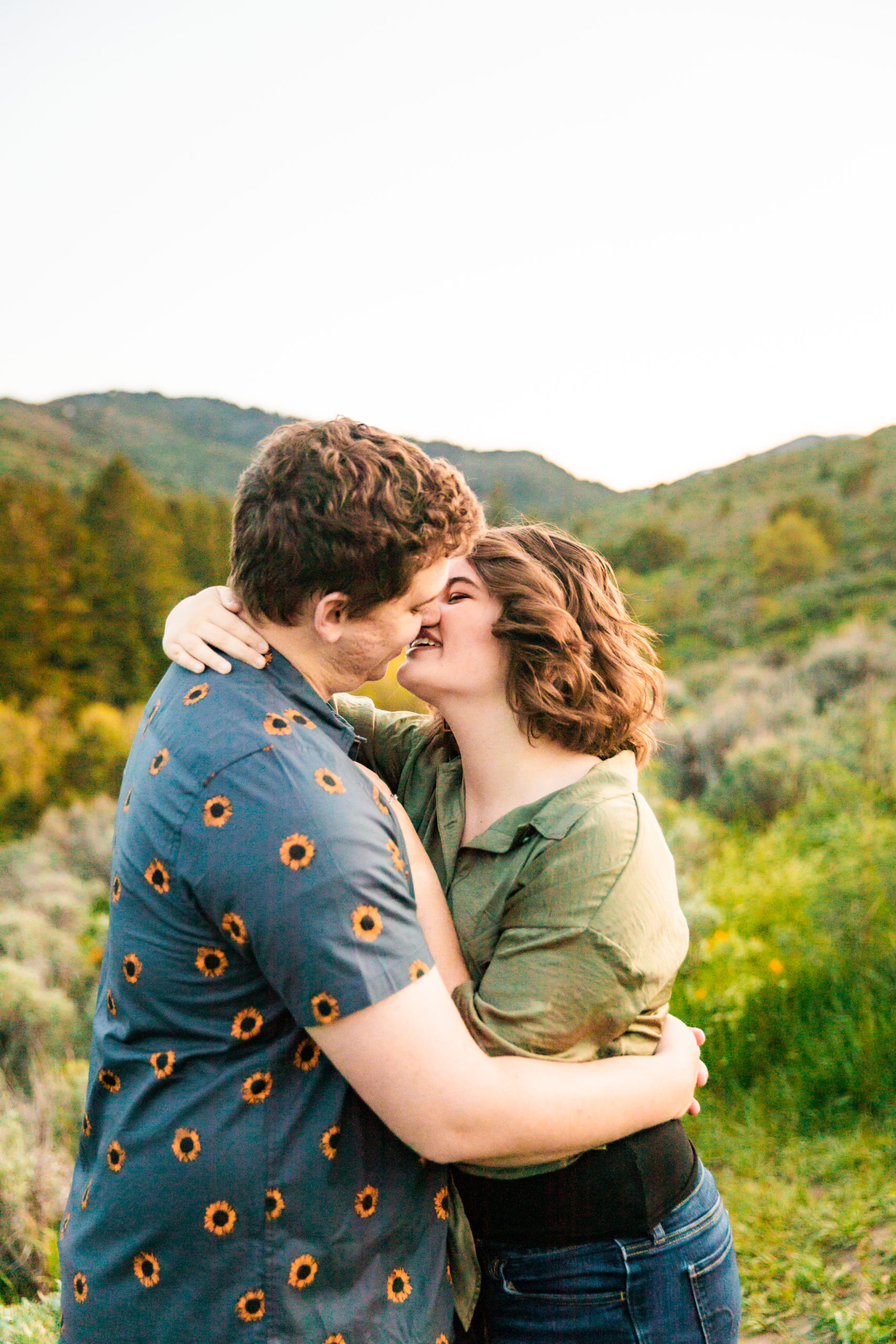 man and woman kissing and embracing during outdoor portraits