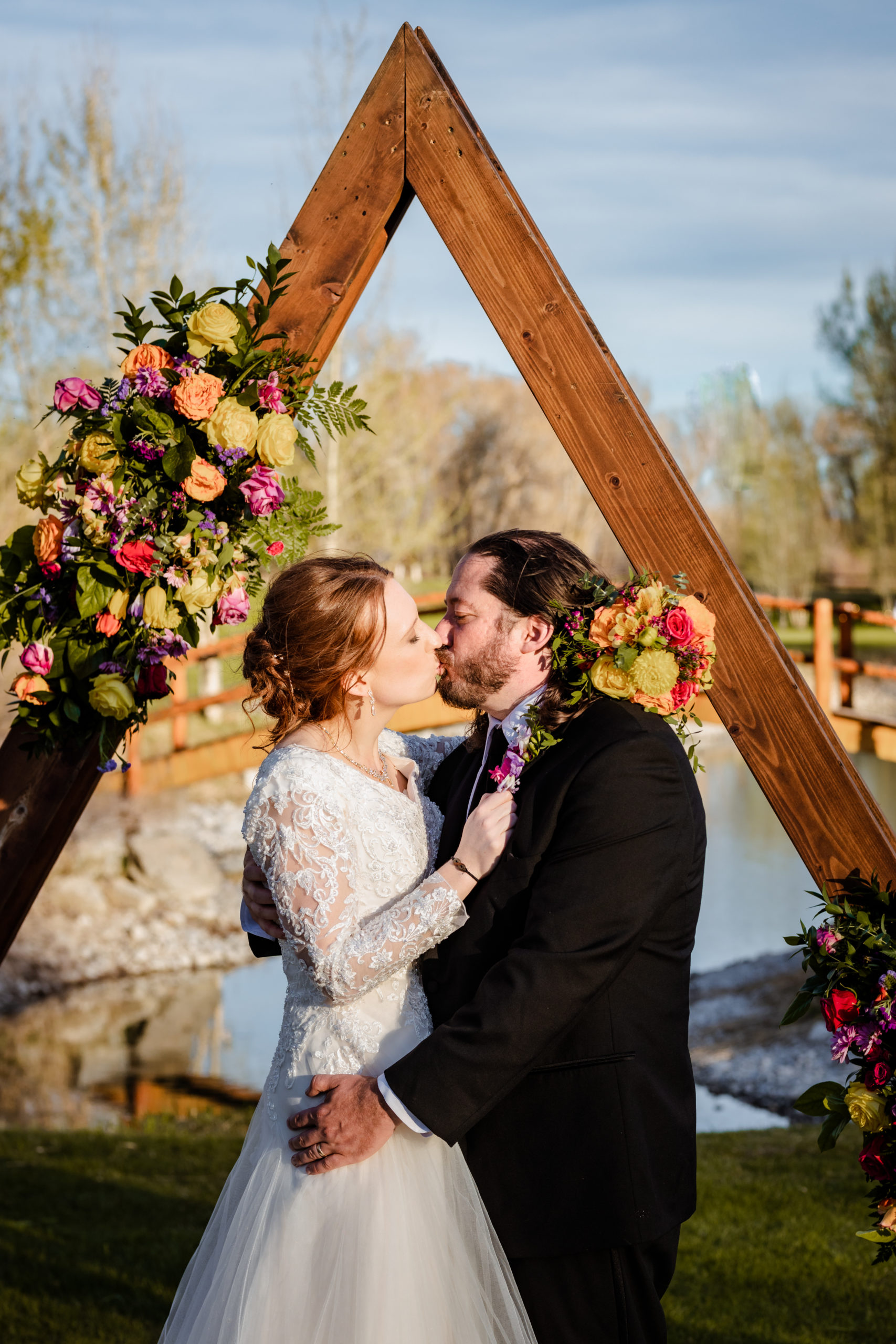 bride and groom kissing at their outdoor Idaho wedding ceremony in the fall