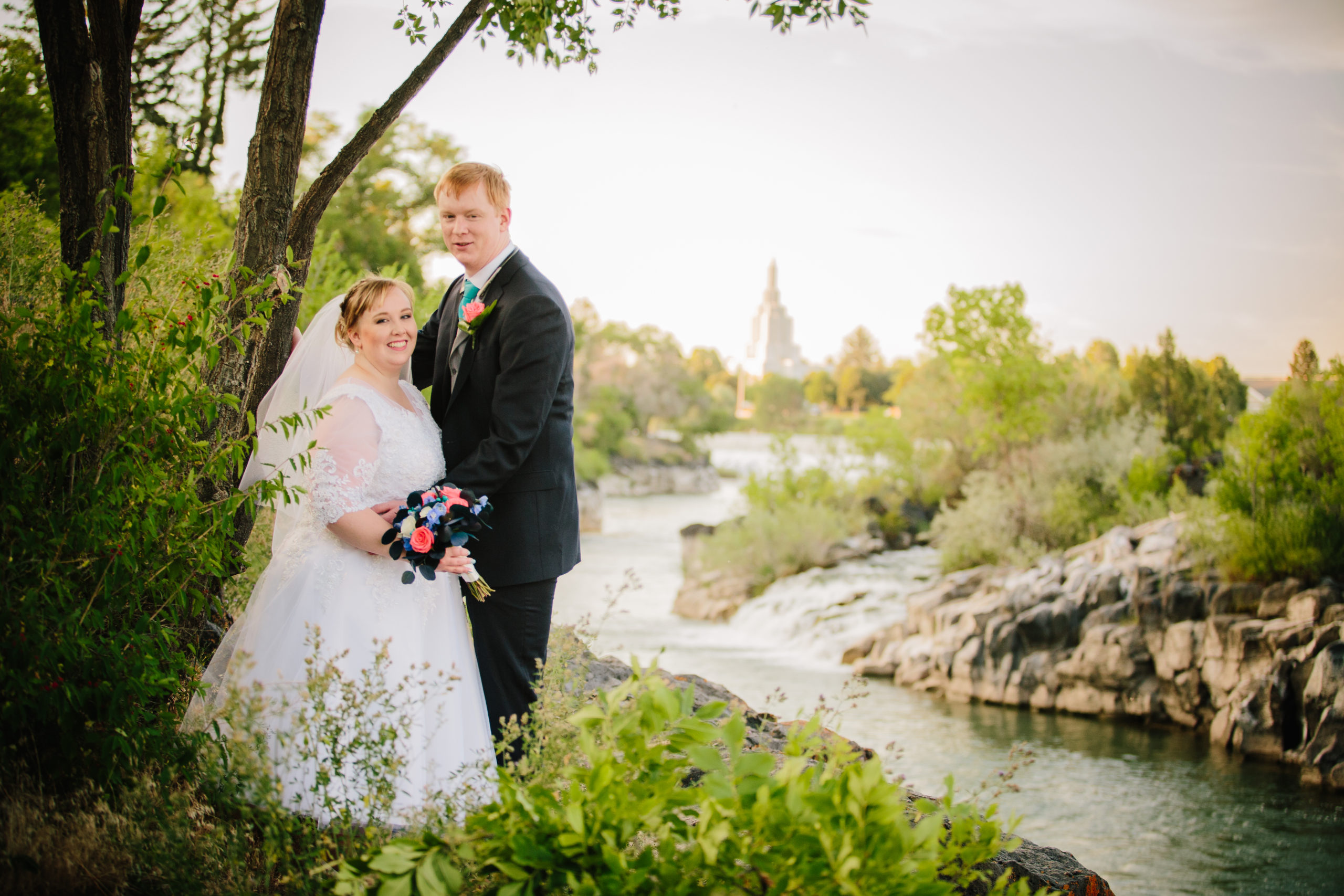 Idaho falls temple next to the water with bride and groom 