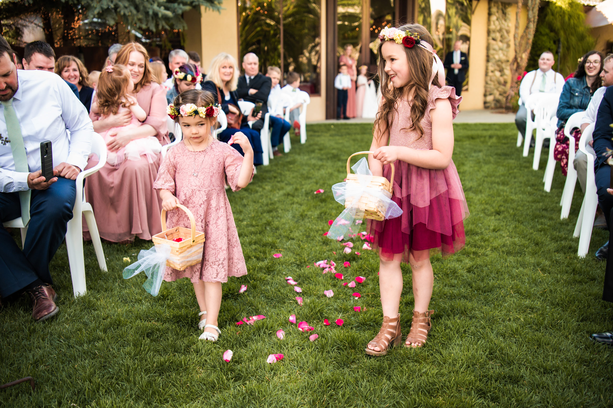 Flower girls at elegant rose river wedding reception center wearing shades of pink tossing flowers