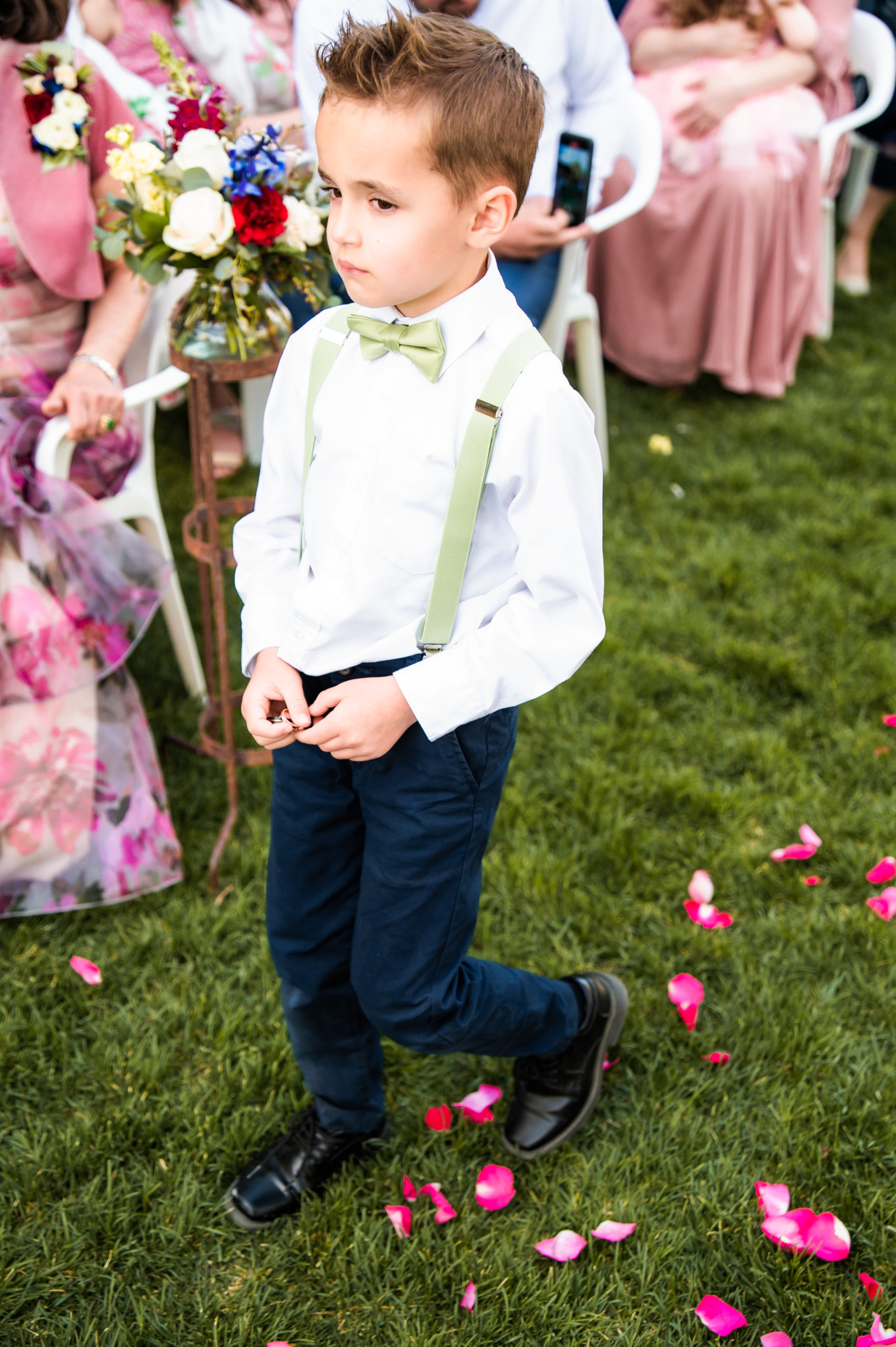 little boy with wedding rings walking towards groom