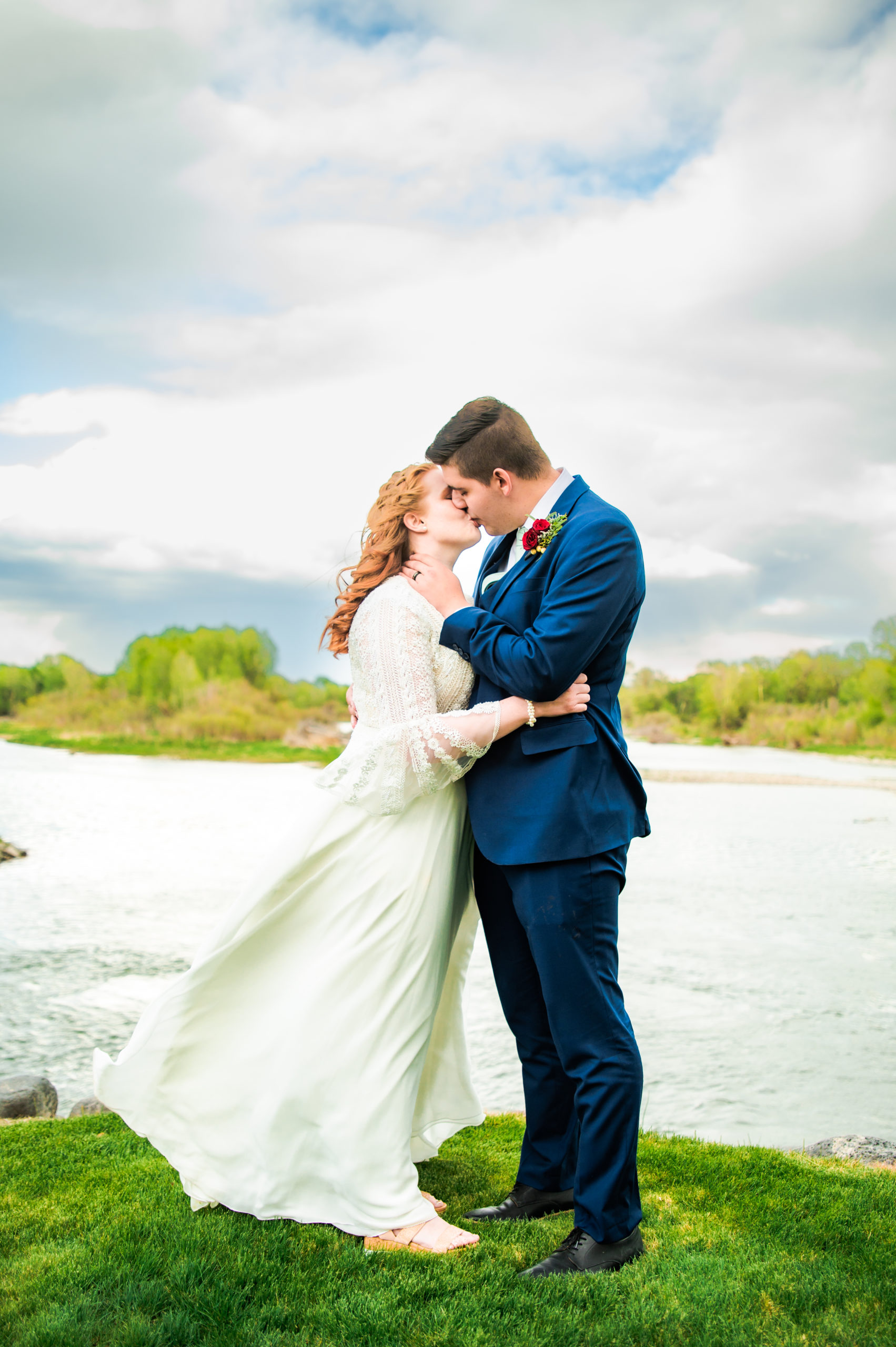 bride and groom kissing at the river at rose river wedding venue