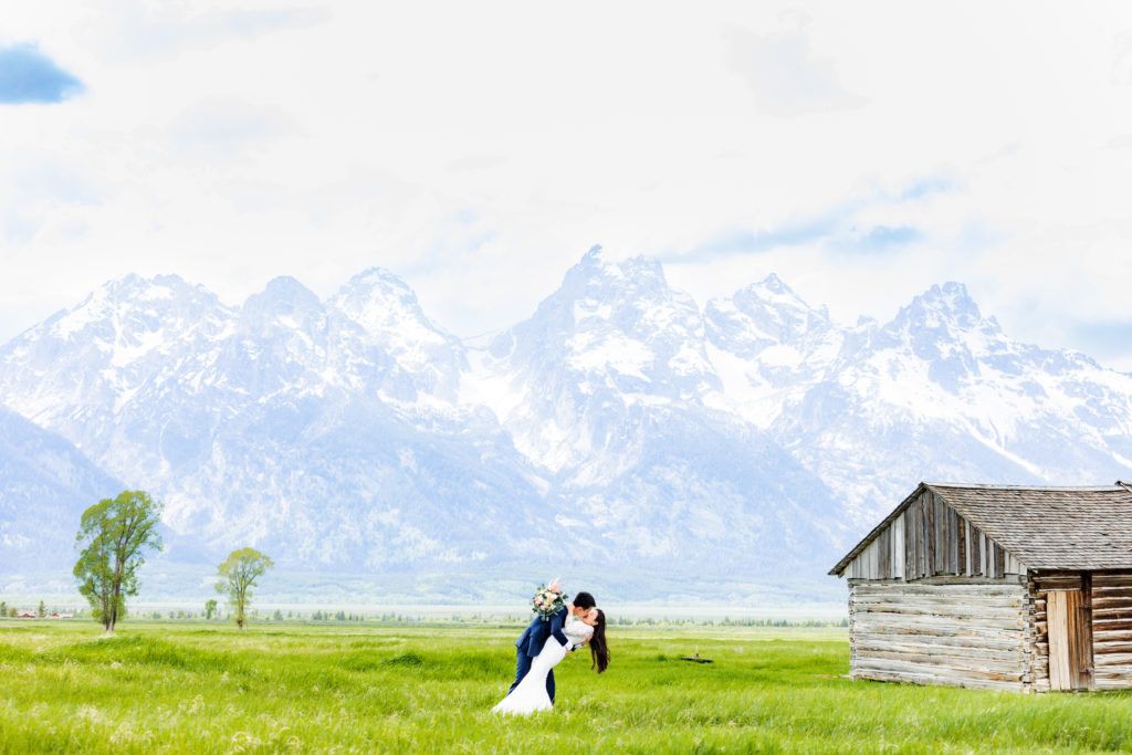bridal couple kissing in front of Grand Tetons after getting married in Grand Teton without a permit