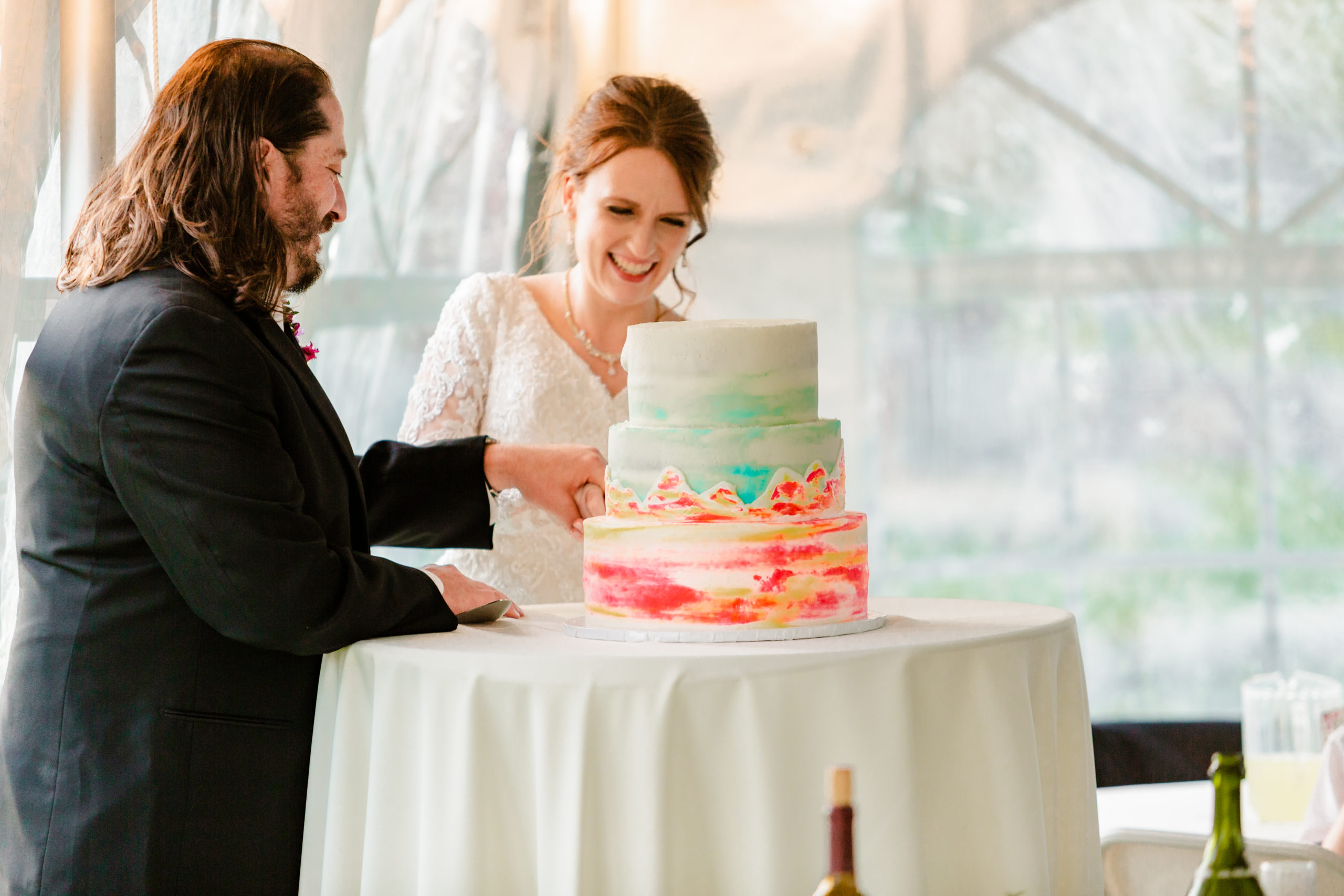 bride and groom cutting cake during Colorful LaBelle Lake Reception