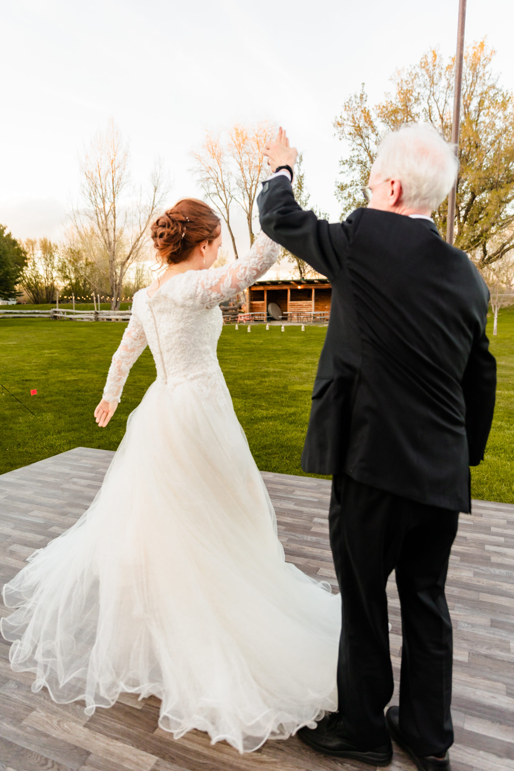 father spinning bride around on dance floor