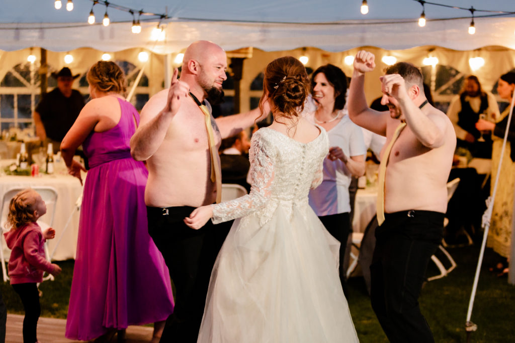 wedding guest with shirt off dancing