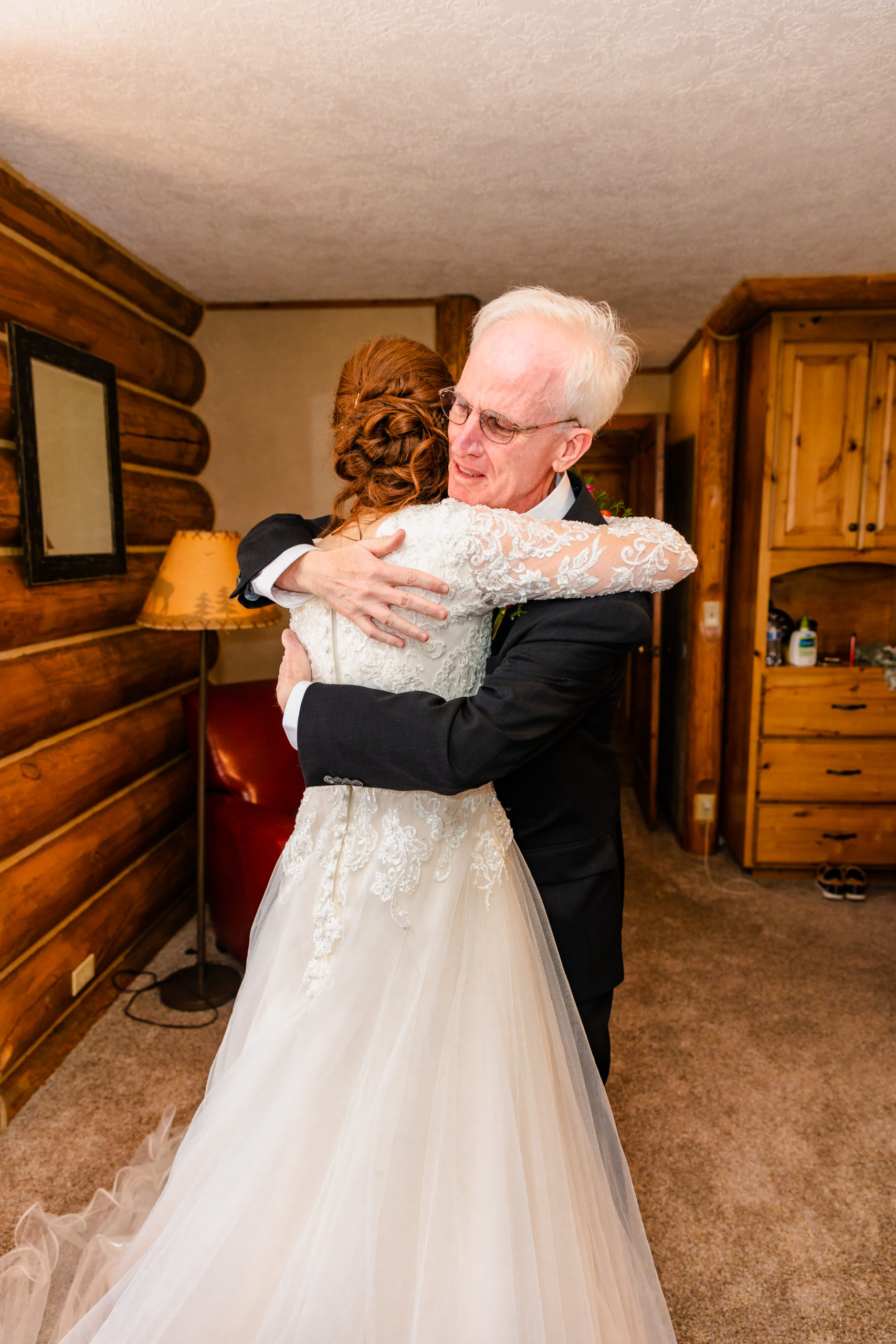 father of the bride crying and hugging bride
