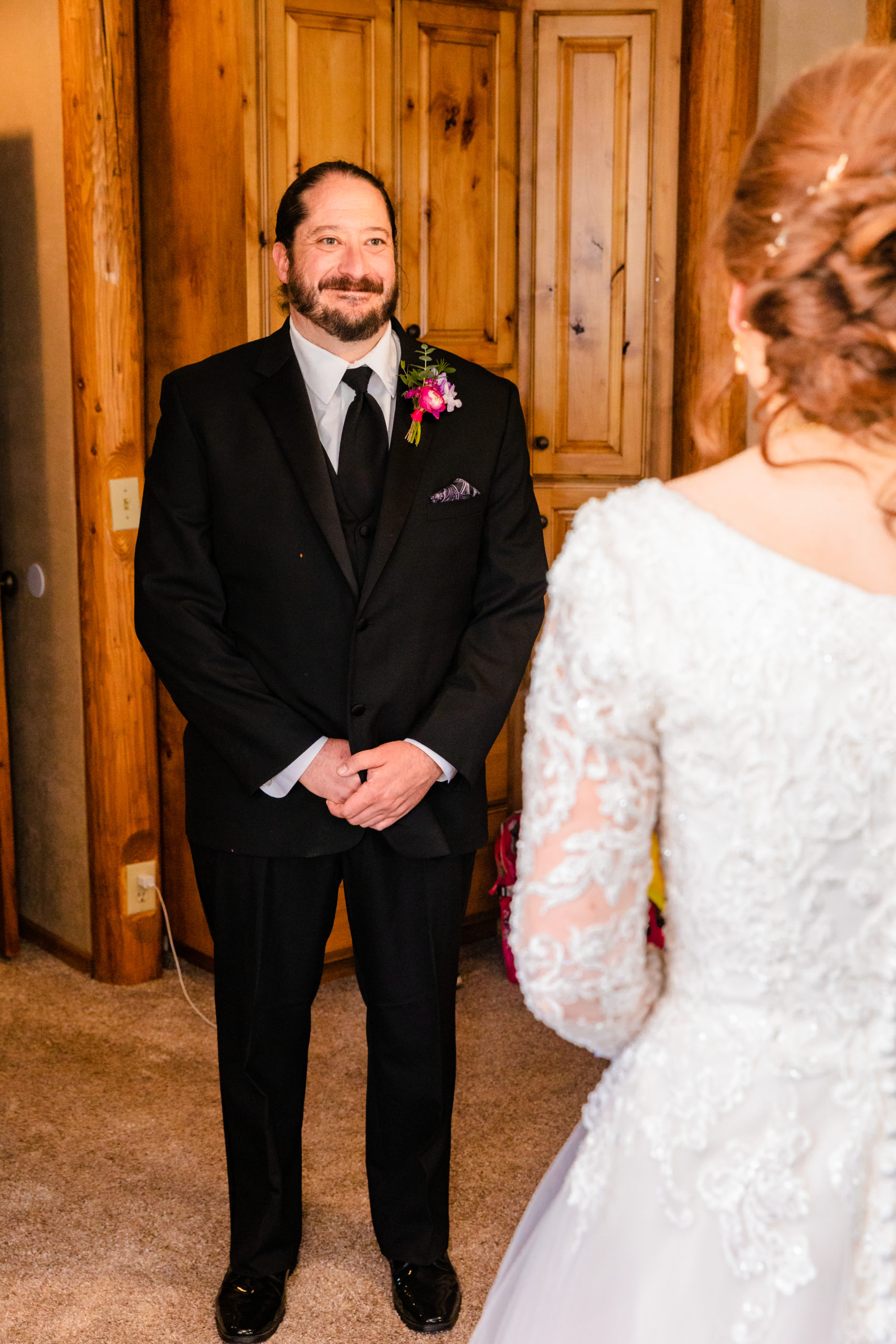 groom seeing bride in dress before wedding smiling so happy