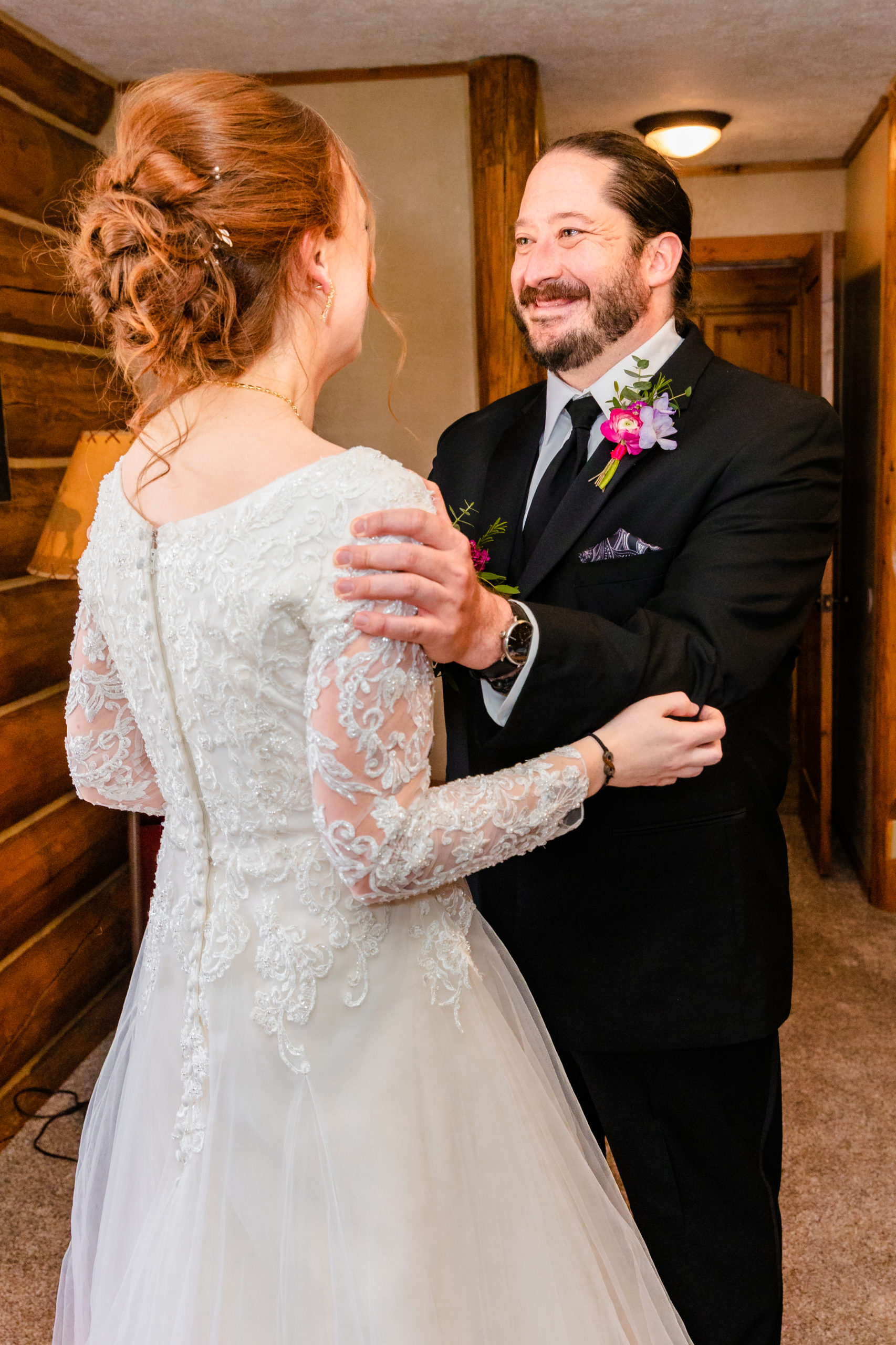 groom holding bride shoulder and smiling ear to ear