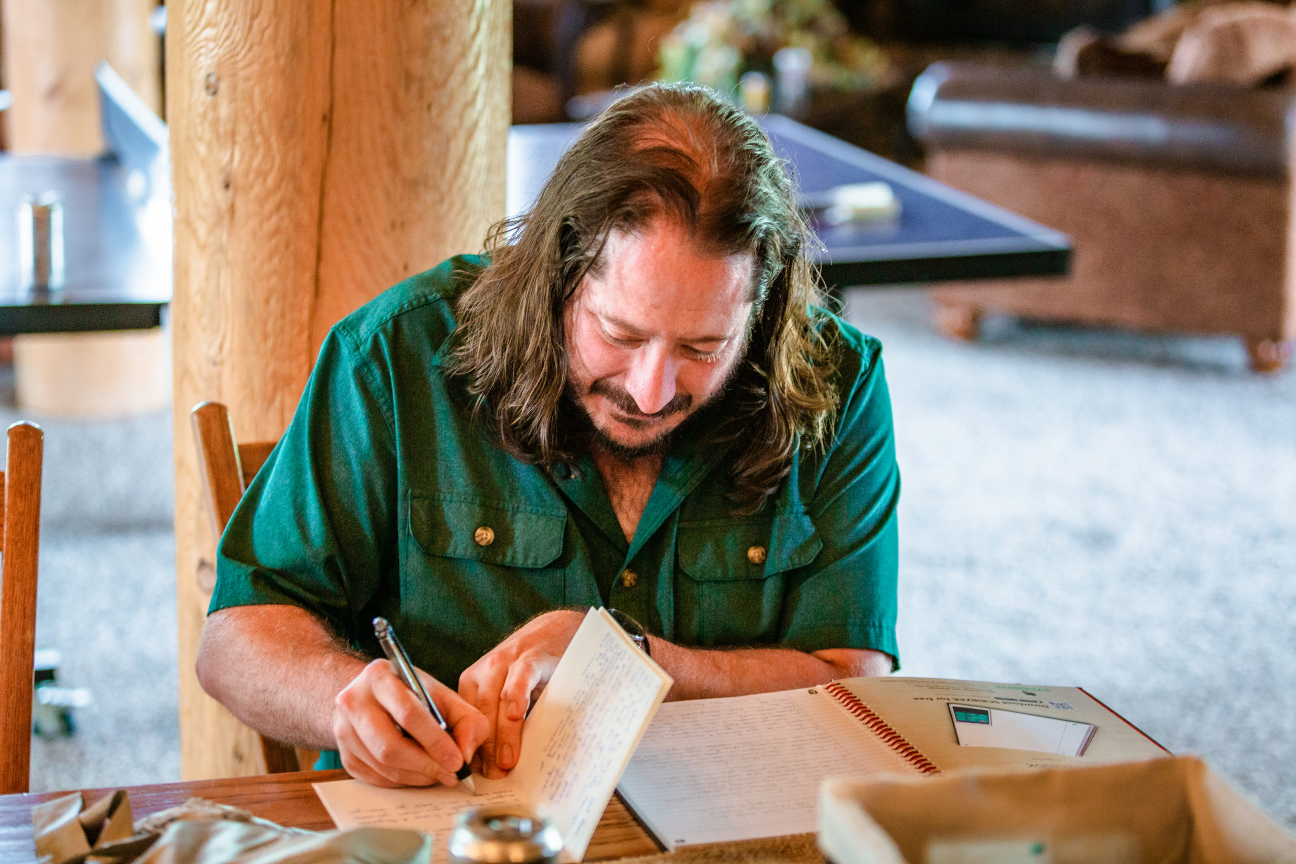 groom writing vows before labelle lake wedding while wearing a green fishing shirt