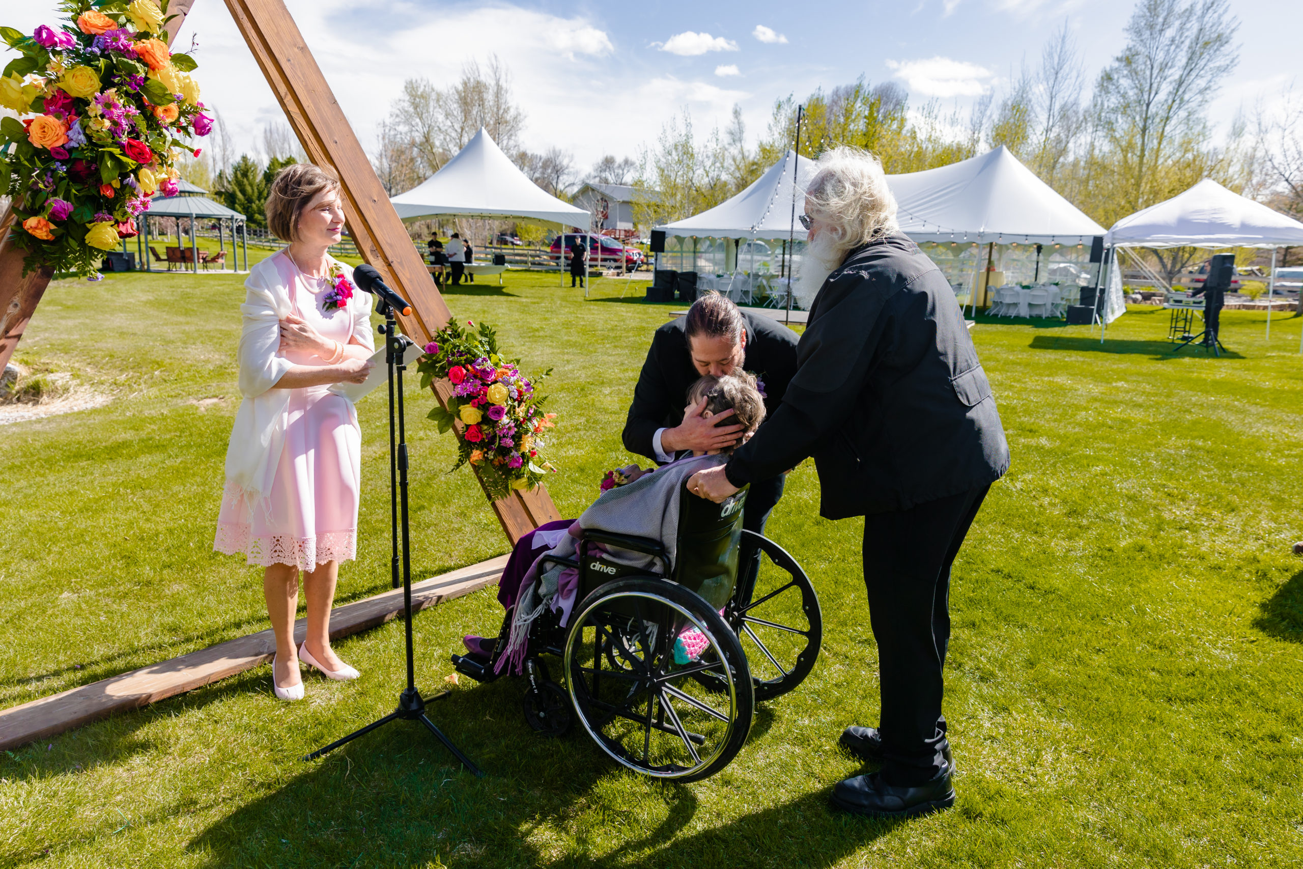 groom kissing mother in wheelchair before wedding 
