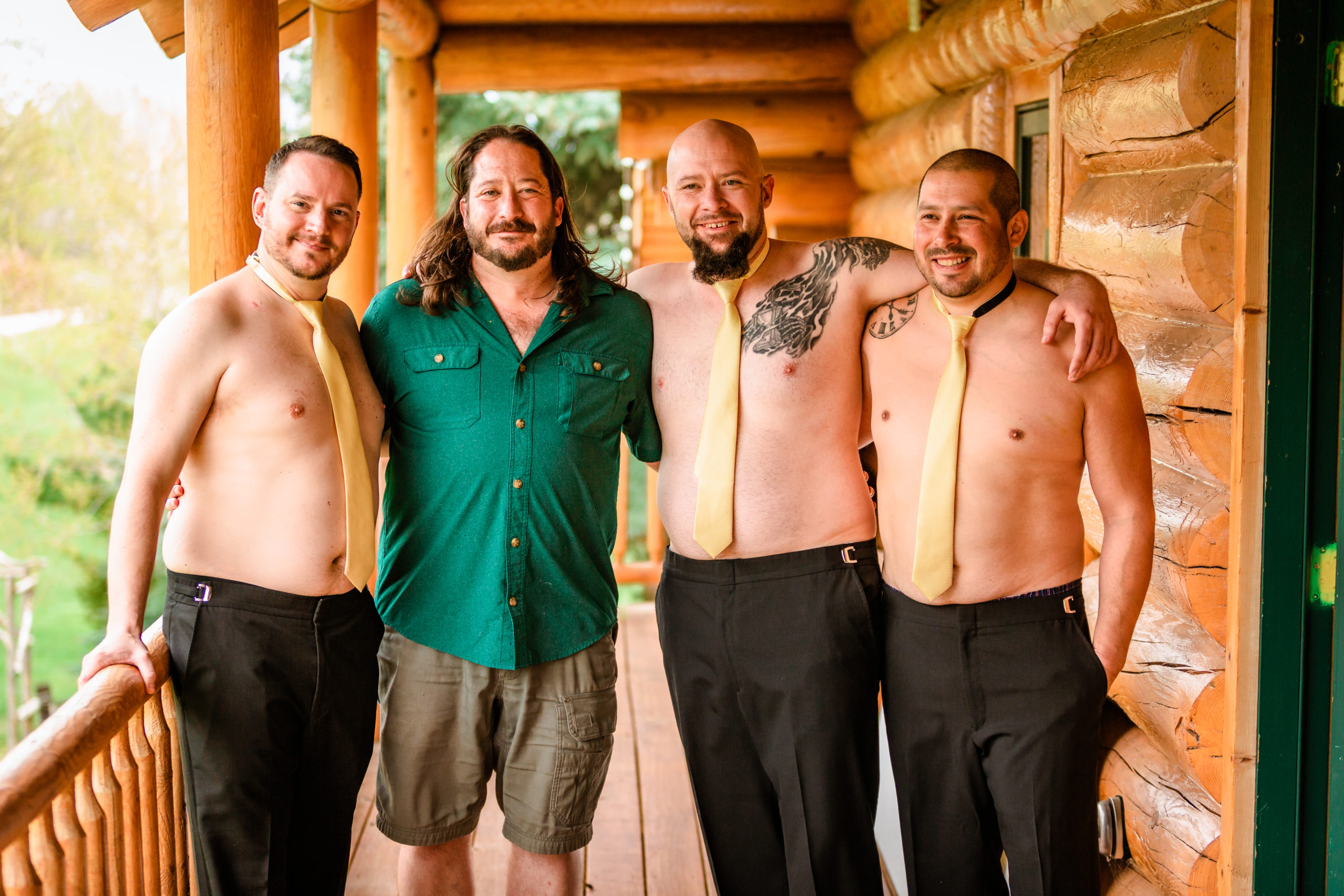 groom in green shirt poses with groomsmen with no shirt by wearing a tie before wedding at LaBelle Lake