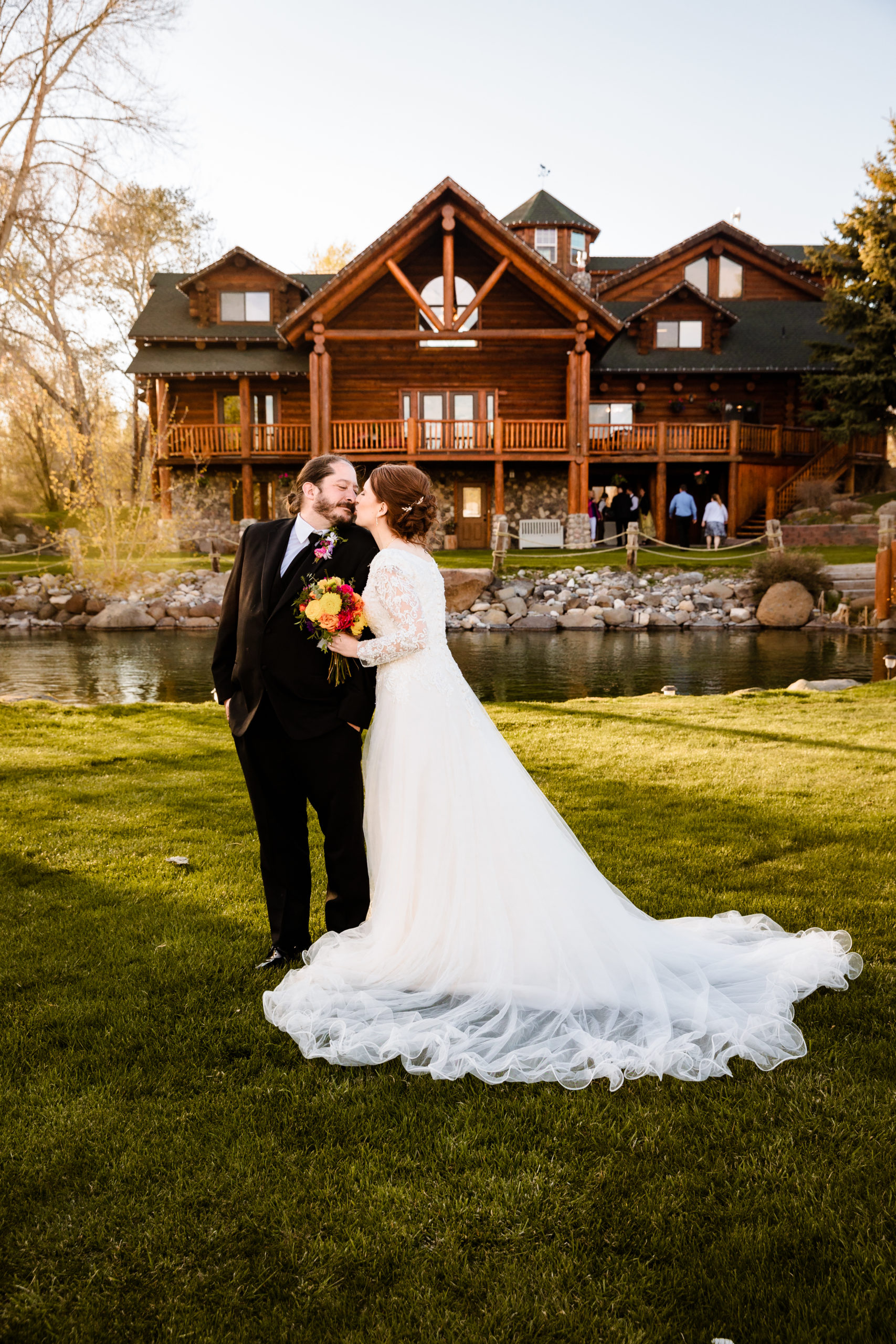 newly married couple kissing in front of Labelle Lake wedding veneu