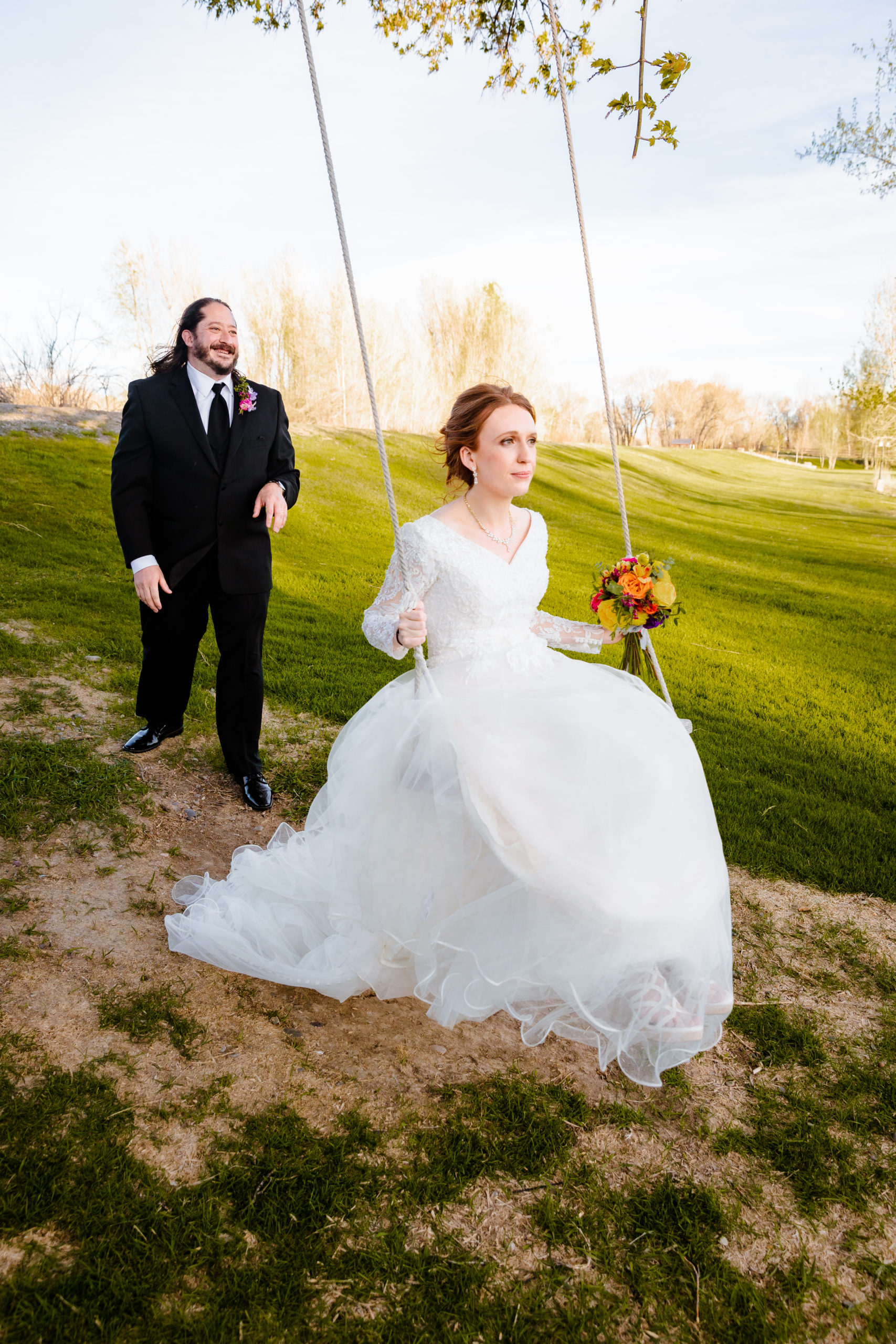 groom pushing bride on swing