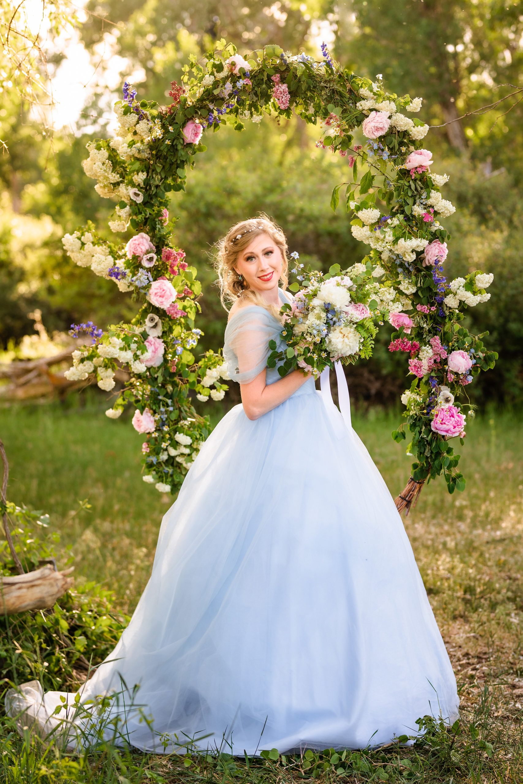 beautiful idaho bride in blue dress surounded by pink and while flowers