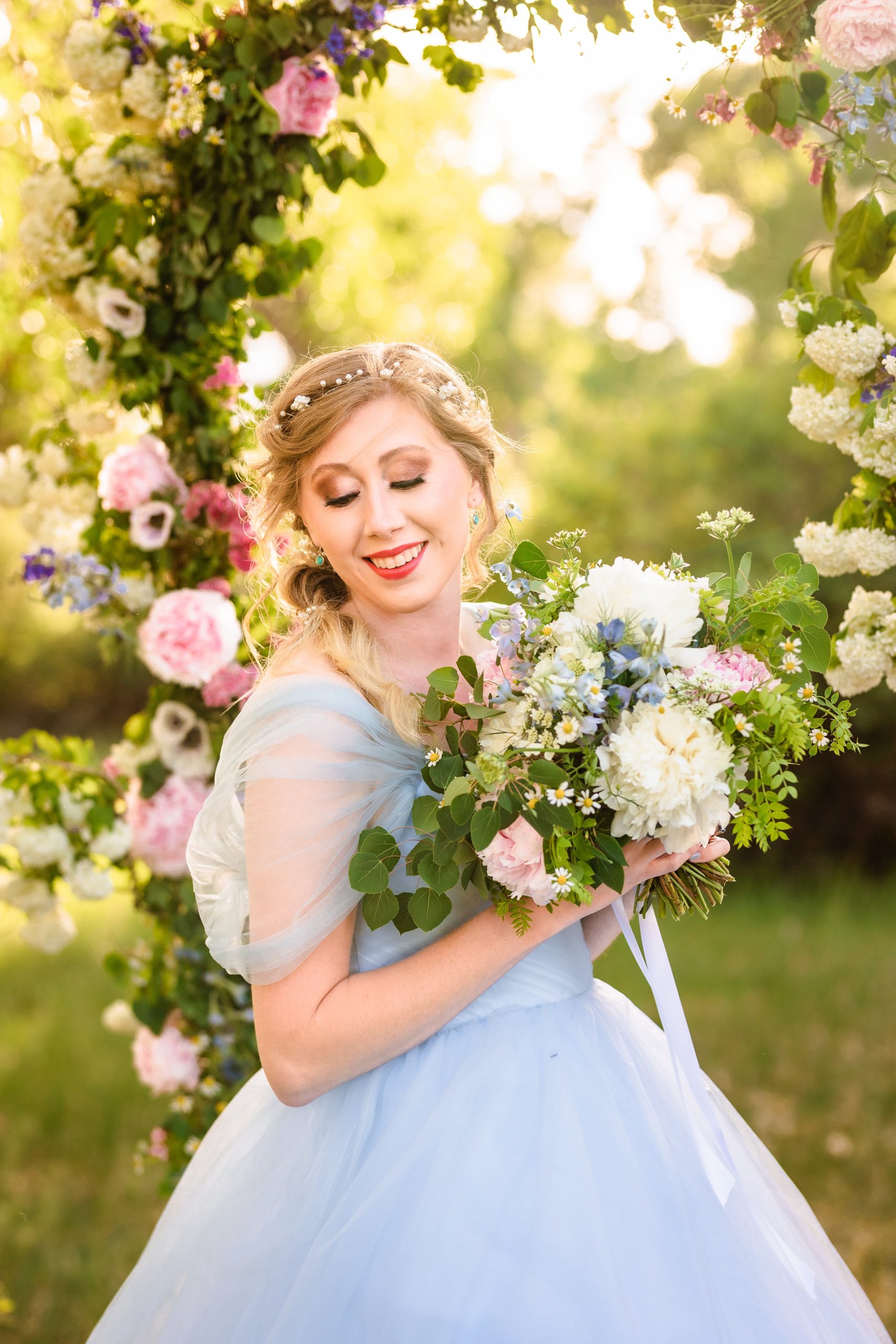 bride gazes at shoulder in blue wedding dress with pink flowers
