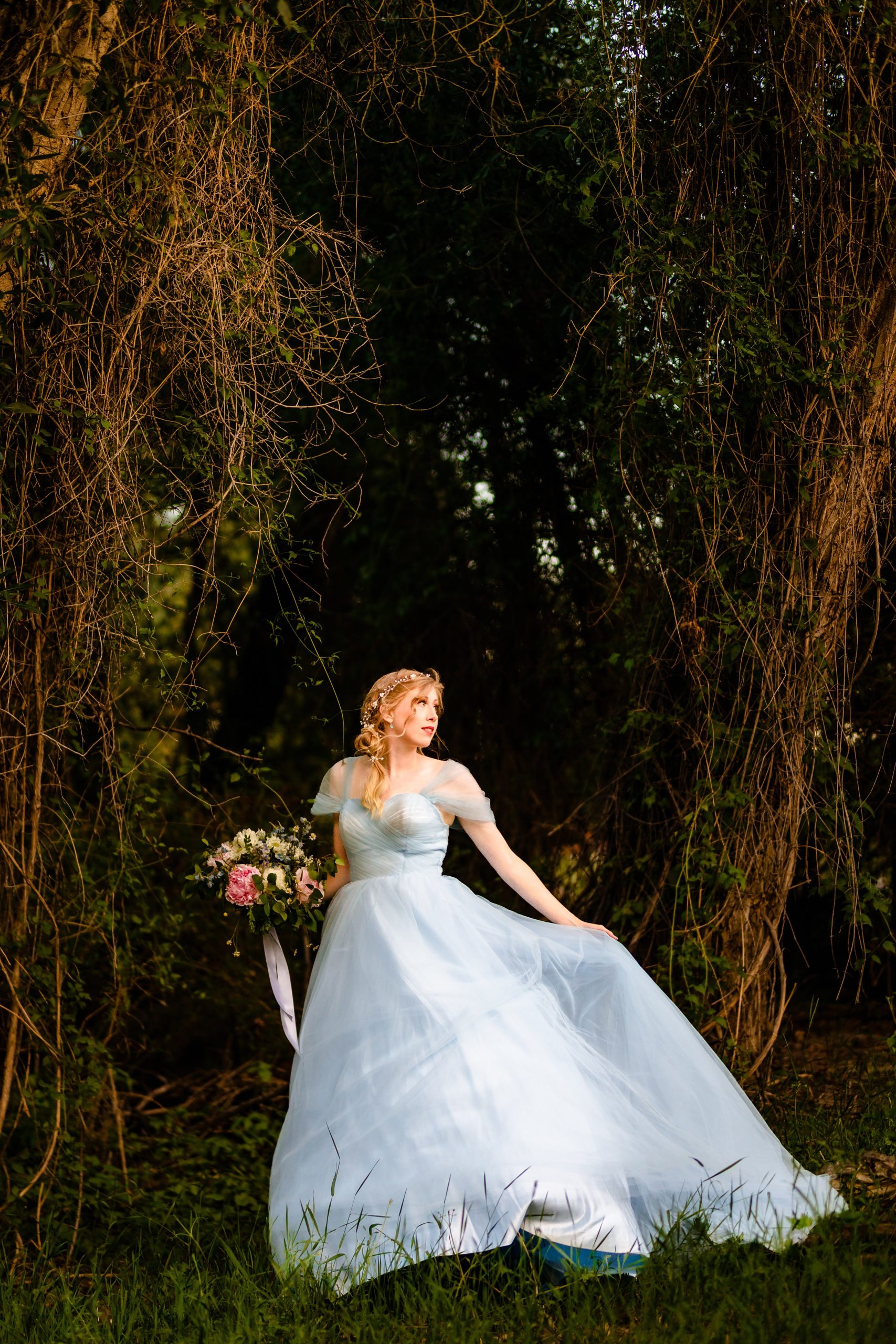 flowing bride in blue dress standing along in forest with wind blowing dress Fun GTNP Elopement Photographer