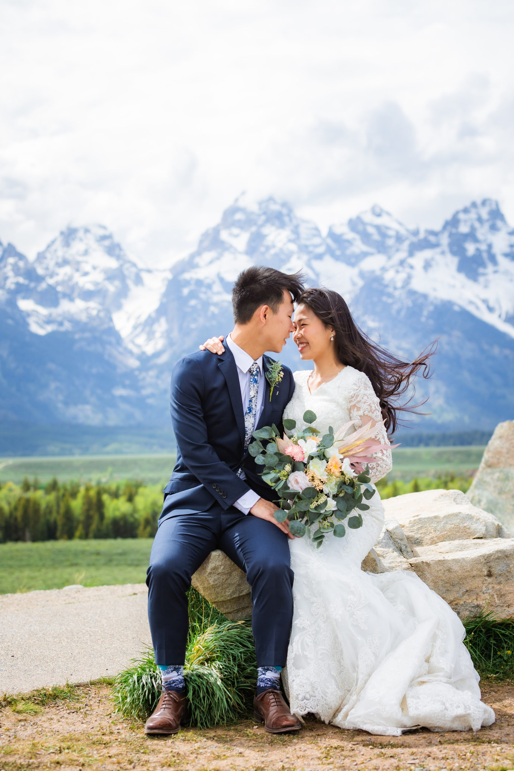 bride and groom sitting together on log during bridals at grand teton elopement