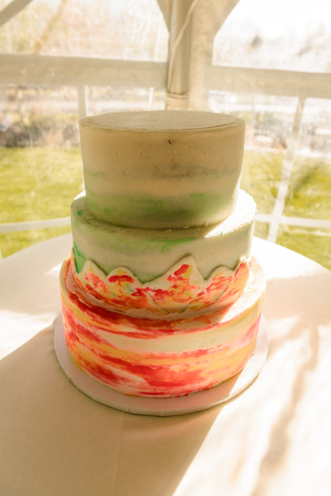 ombre mountain wedding cake with teals and peachy colors from blackfoot wedding vendor Paisley Cakes