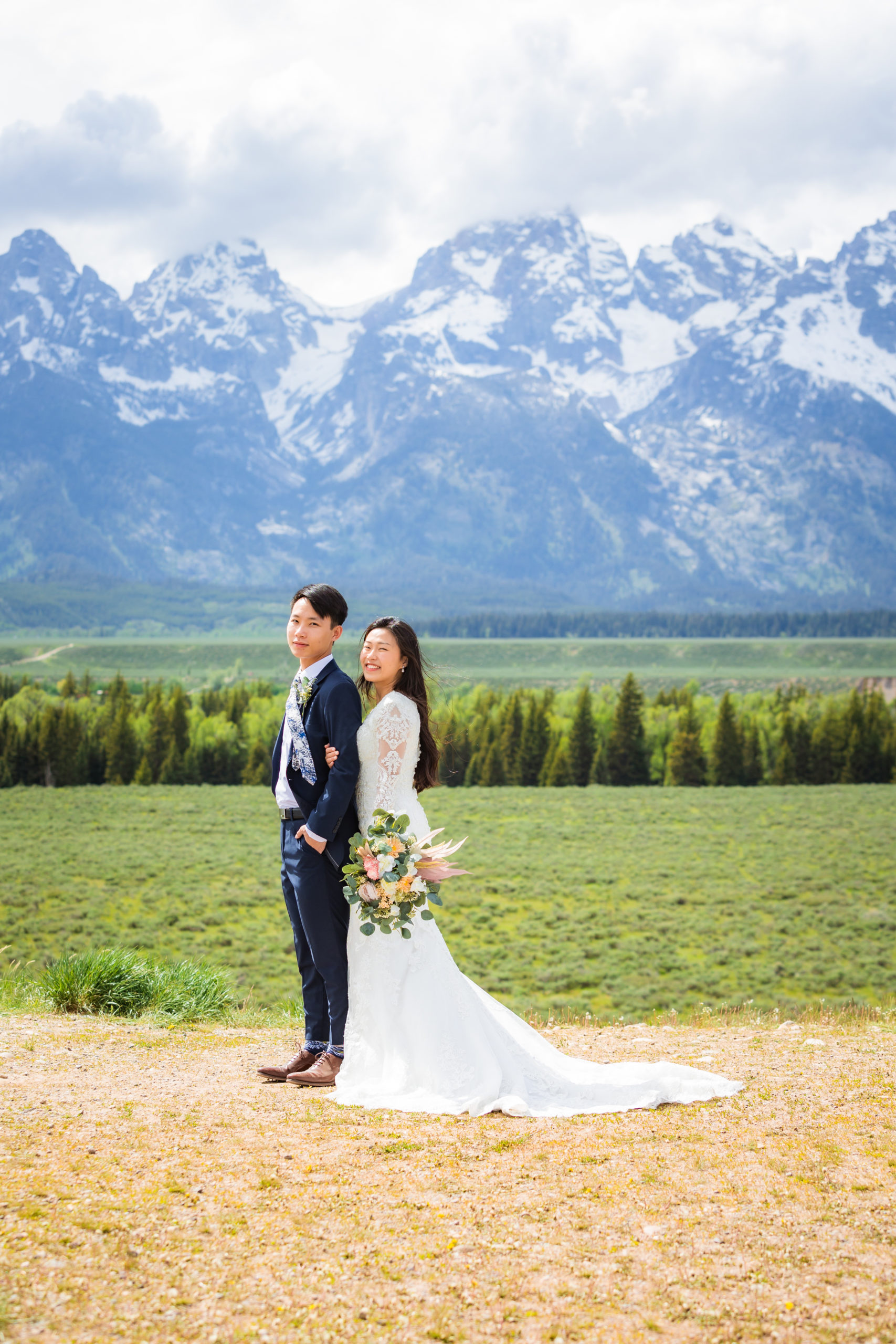 summer elopement with bride standing behind groom and holding him for wedding portraits by Grand Teton wedding photographer