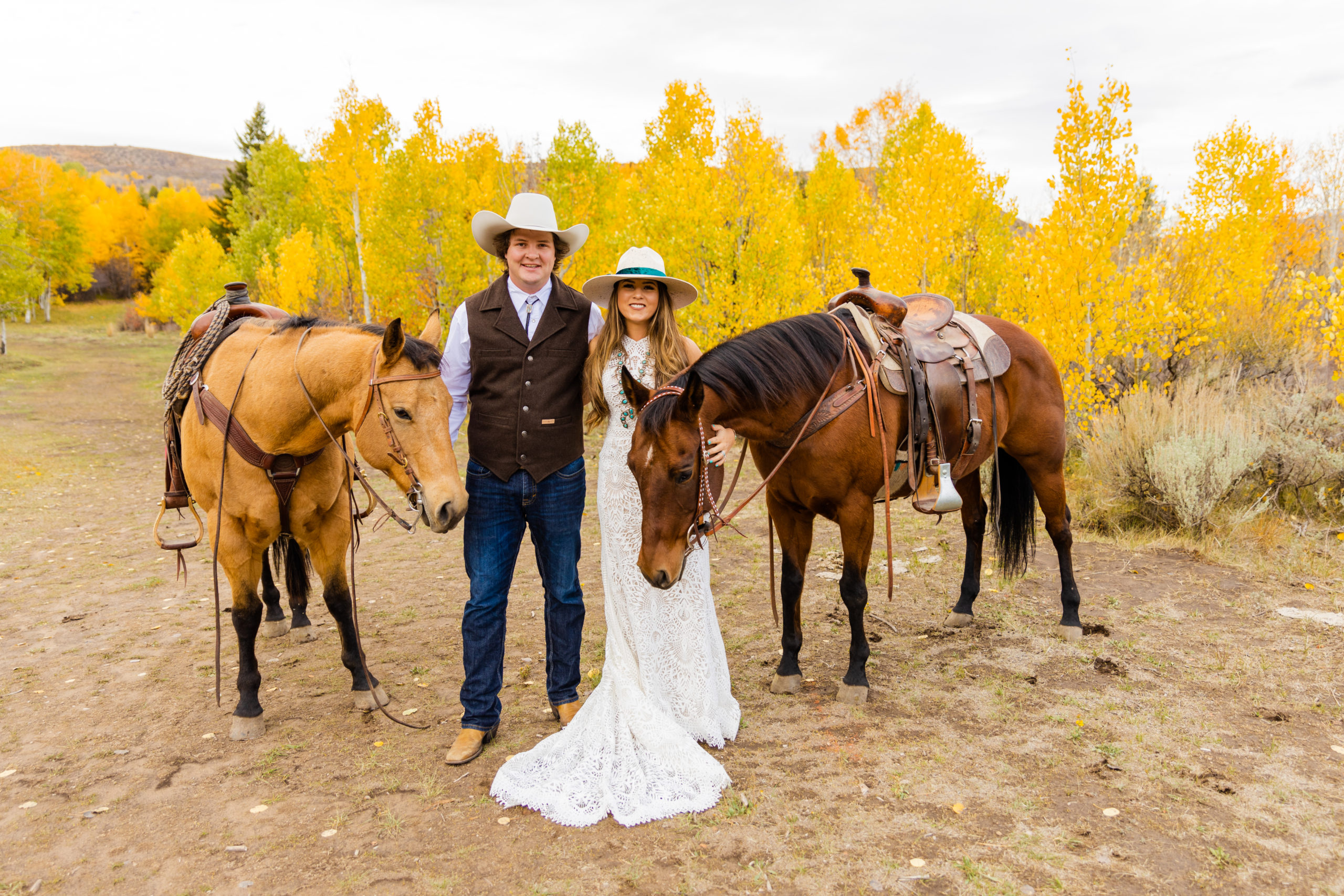 bride and groom standing together with their horses for their outdoor wedding photos with Grand Teton wedding photographer