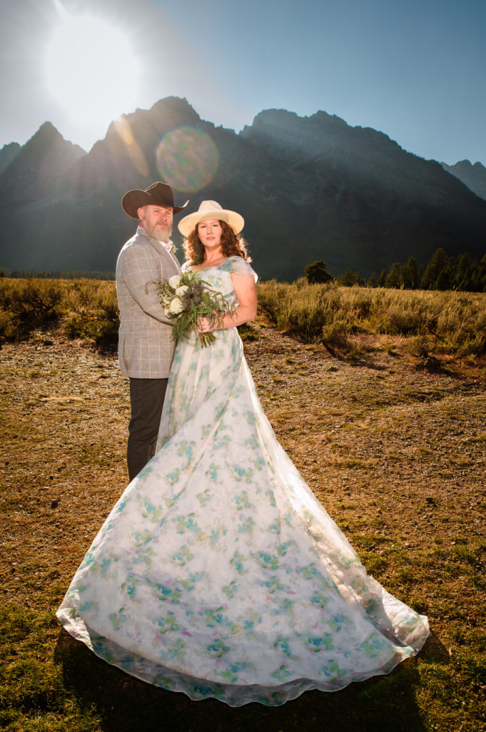 jackson hole wedding photographer captures bride and groom standing in grand teton national park at golden hour