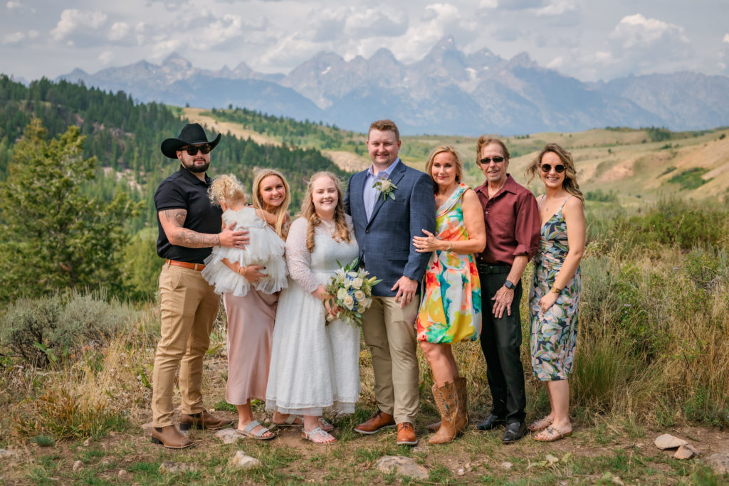 Jackson Hole wedding photographers capture bride and groom standing with family after Windy Wedding Tree Elopement 