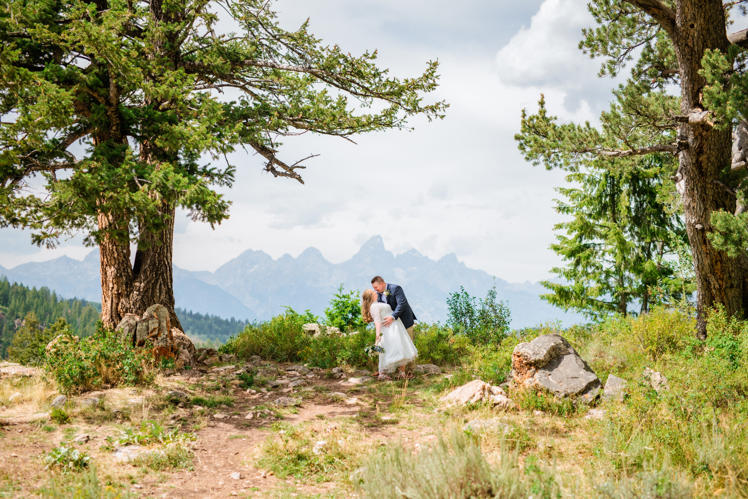 Jackson Hole wedding photographer captures couple dip kiss at wedding tree in Grand Teton National Park wedding