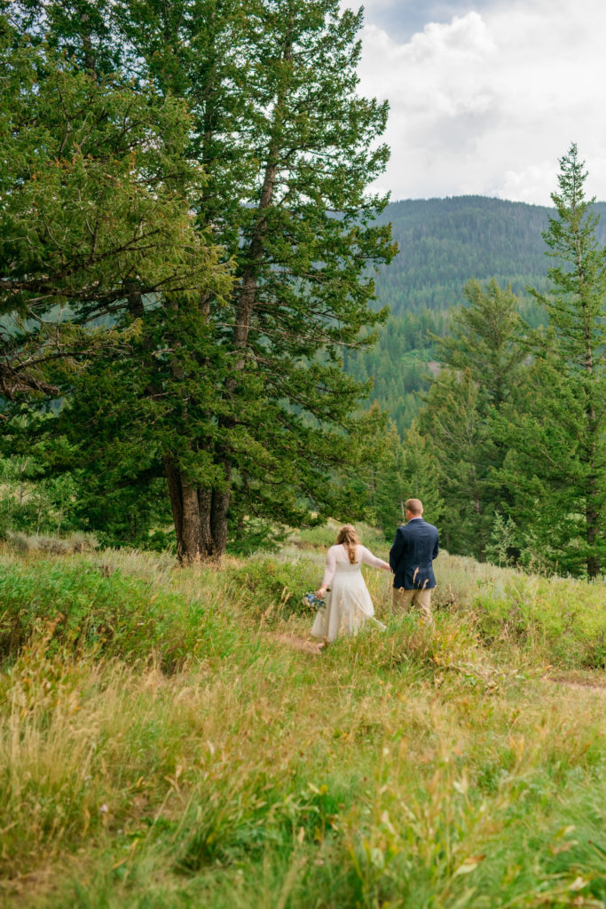 Jackson Hole wedding photographer captures bride and groom walking off after ceremony together