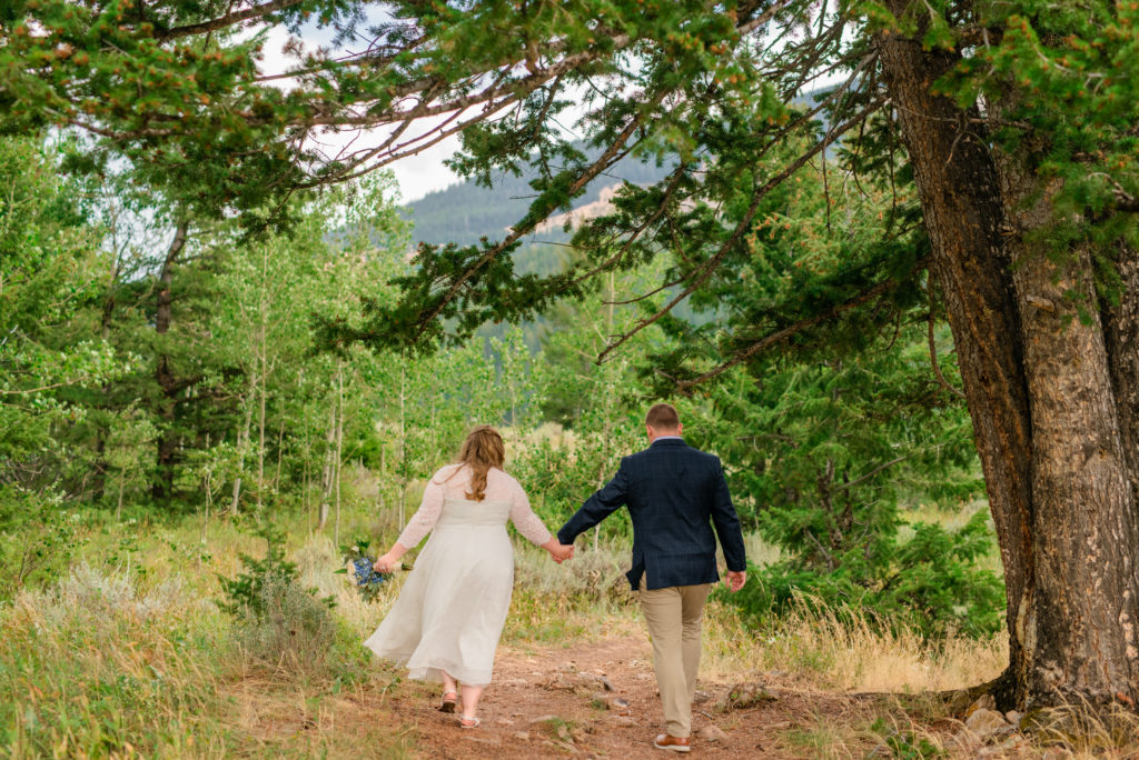 Jackson Hole wedding photographers capture bride and groom walking around Grand Teton National Park as husband and wife