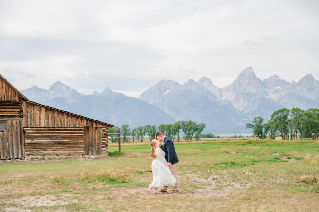 Jackson Hole wedding photographer captures wedding couple walking around mormon row in grand teton national park