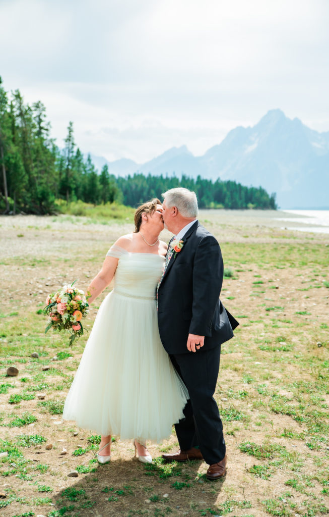 jackson hole wedding phtoographer captures bride and groom kissing during portraits