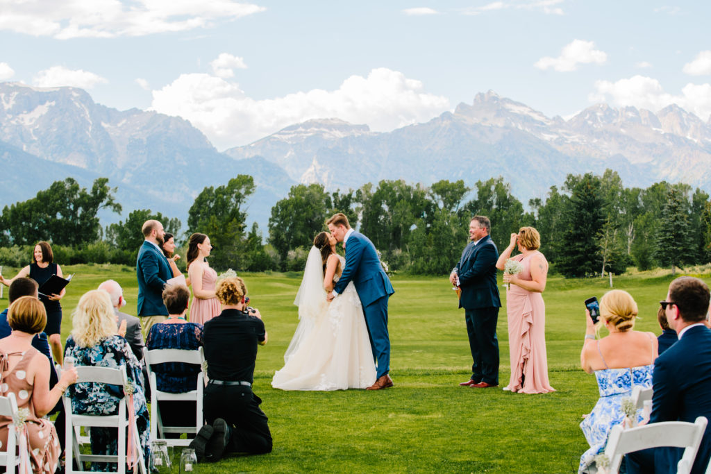 Jackson Hole wedding photographer captures bride and groom kissing as husband and wife at jackson hole wedding venue