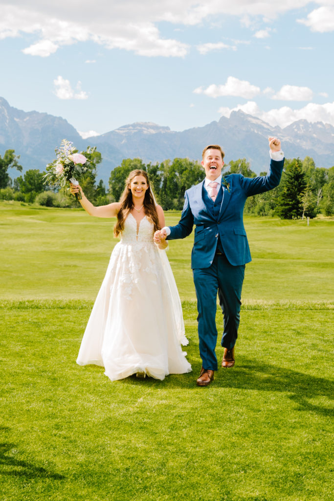 Jackson Hole wedding photographer captures bride and groom walking through golf course 