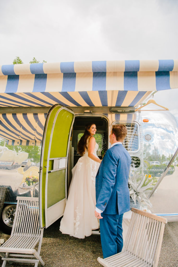 Jackson Hole wedding photographer captures bride and groom walking into vintage bus