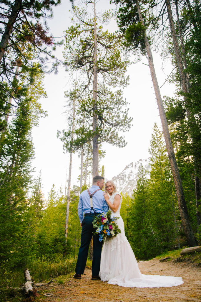 Jackson Hole wedding photographer captures bride and groom hugging in forest in grand teton national park