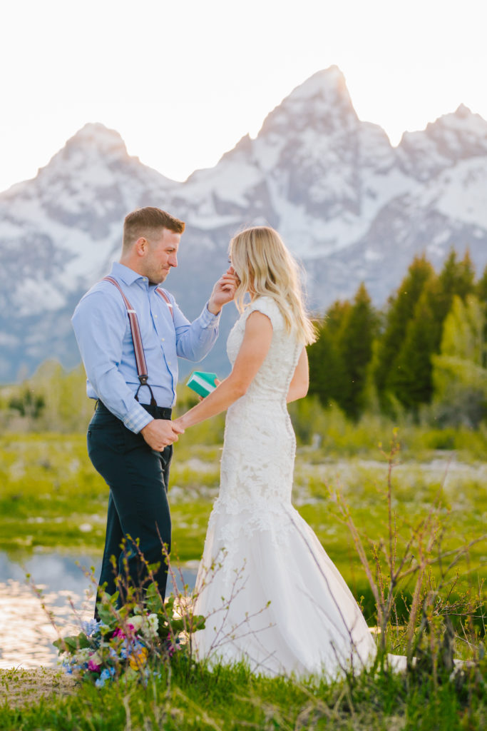 Jackson Hole wedding photographer captures groom wiping tears from bride's face