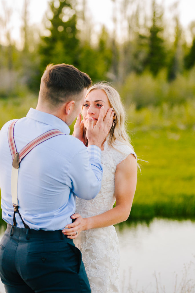 Jackson Hole wedding photographer captures groom wiping bride's tears from her face