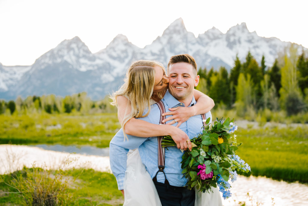 Jackson Hole wedding photographer captures bride on groom's back laughing