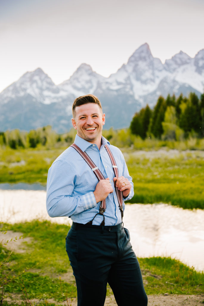 Jackson Hole wedding photographer captures groom wearing blue shirt and holding suspenders